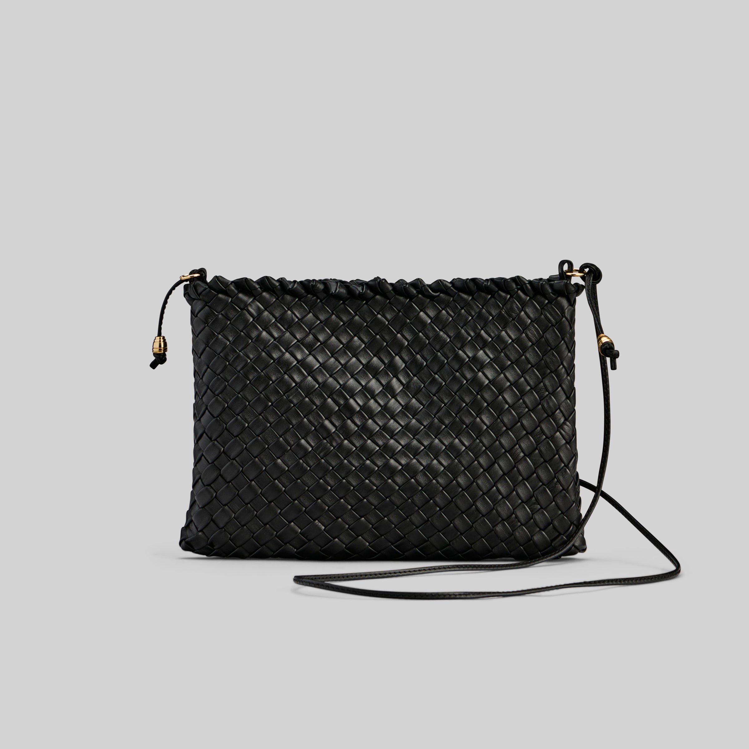Ribichini Woodstock-clutchen i sort skinn har et detaljert flettet mønster og fine gulldetaljer, som gir et snev av luksus.