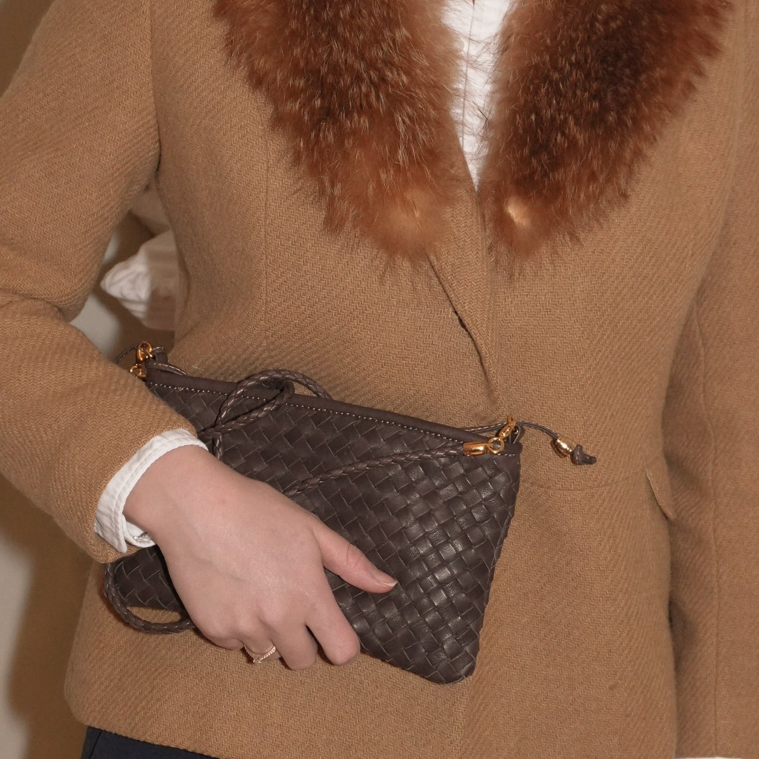 Ribichini Camper Clean clutch i brunt, håndflettet italiensk skinn. Elegant og tidløs veske holdt i hånden.