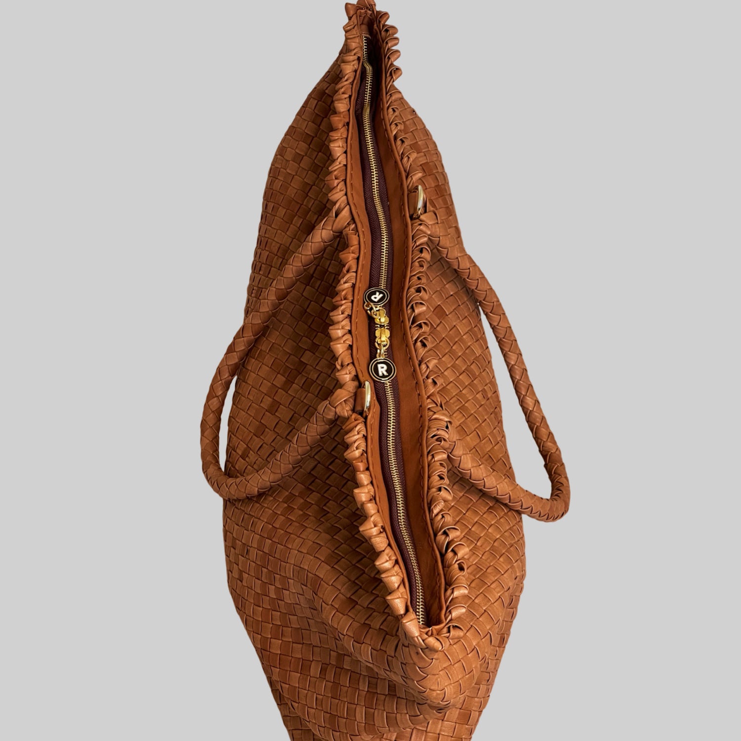 En oversikt over en Ribichini Woodstock Weekend-veske i cognacfarget lammeskinn med gullfargede detaljer og romslig interiør.