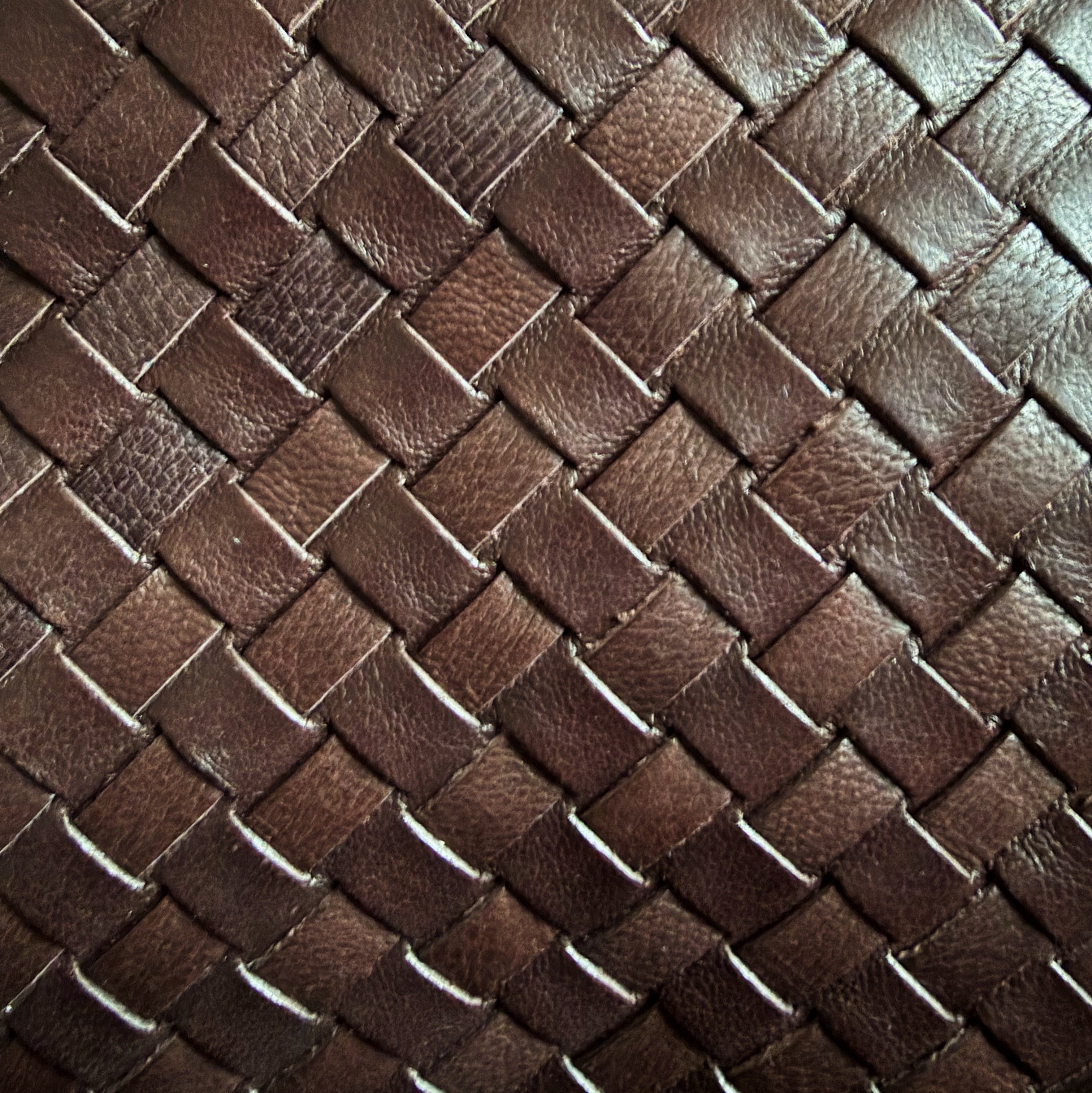 Eksklusivt nærbilde av Camper Clutch i brunt, håndflettet skinn med naturlig glans.