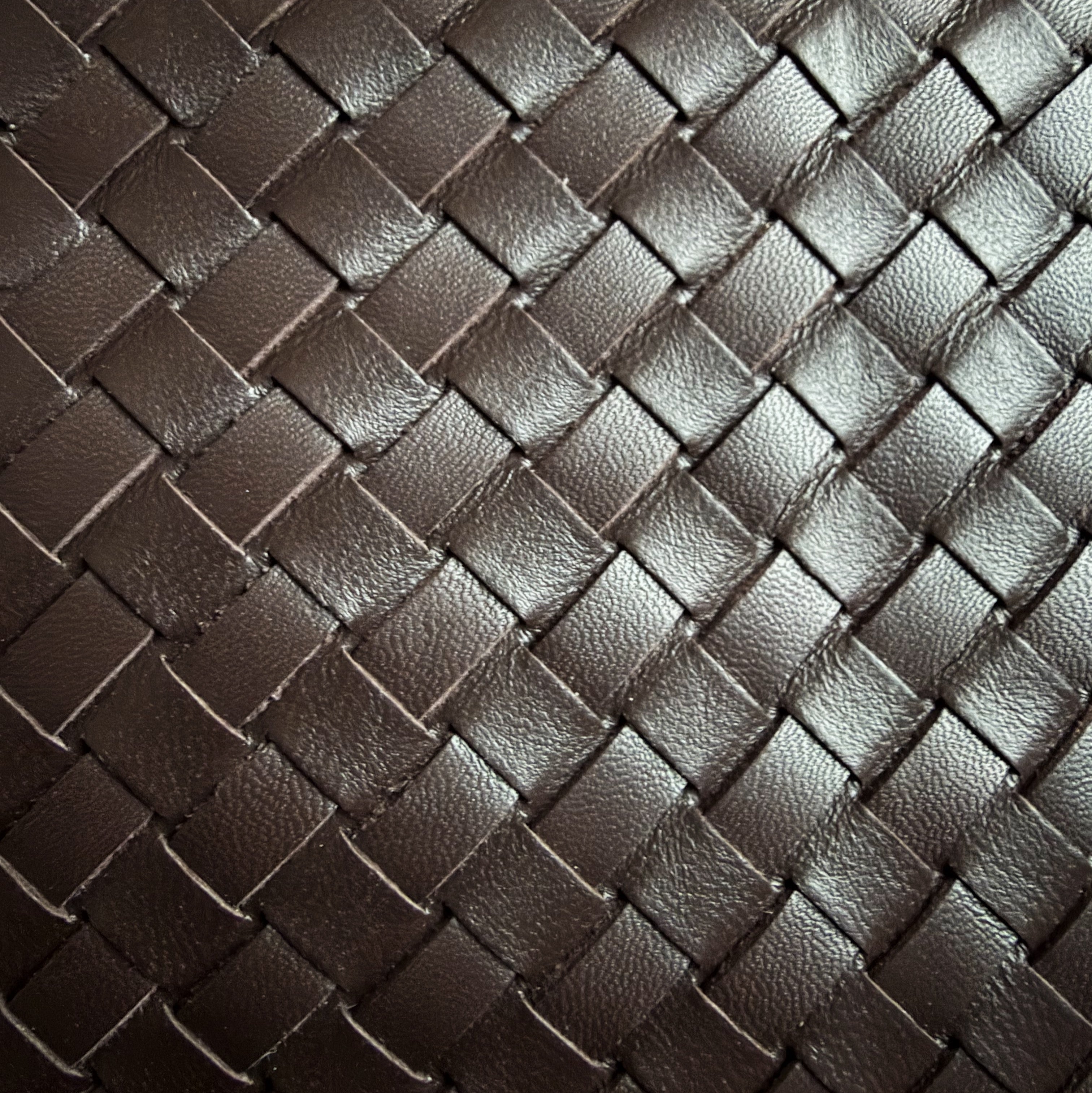 Eksklusivt nærbilde av Camper Clutch i chocolate, håndflettet skinn med naturlig glans.