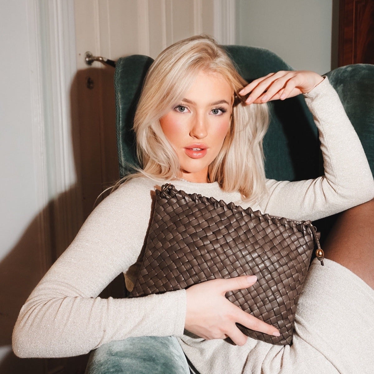 Ribichini Woodstock-clutchen i brunt skinn kombinerer elegant flettedesign med praktisk funksjonalitet,
