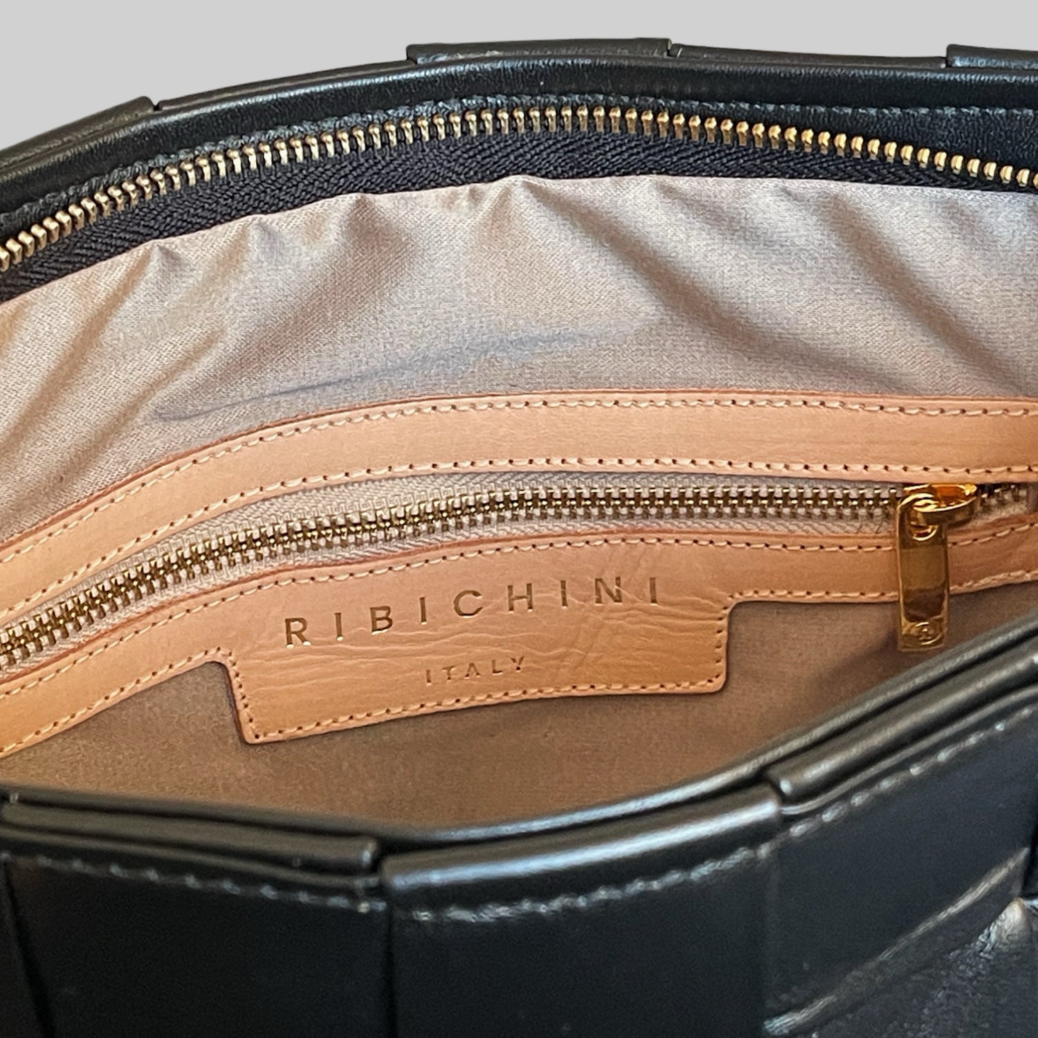 Ribichini Square Laptop i sort – eksklusiv veske i håndflettet skinn med elegant fór, innvendig glidelåslomme og skinnlogo.