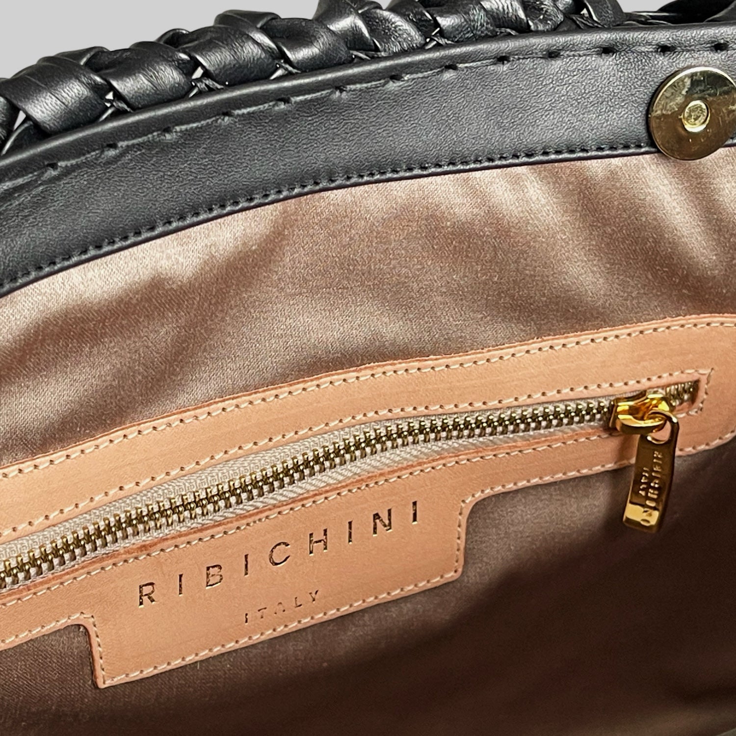 Detalj av interiøret i Ribichini Woodstock Classic Babe, viser glidelåslomme i skinn med preget logo og gullfarget glidelås.