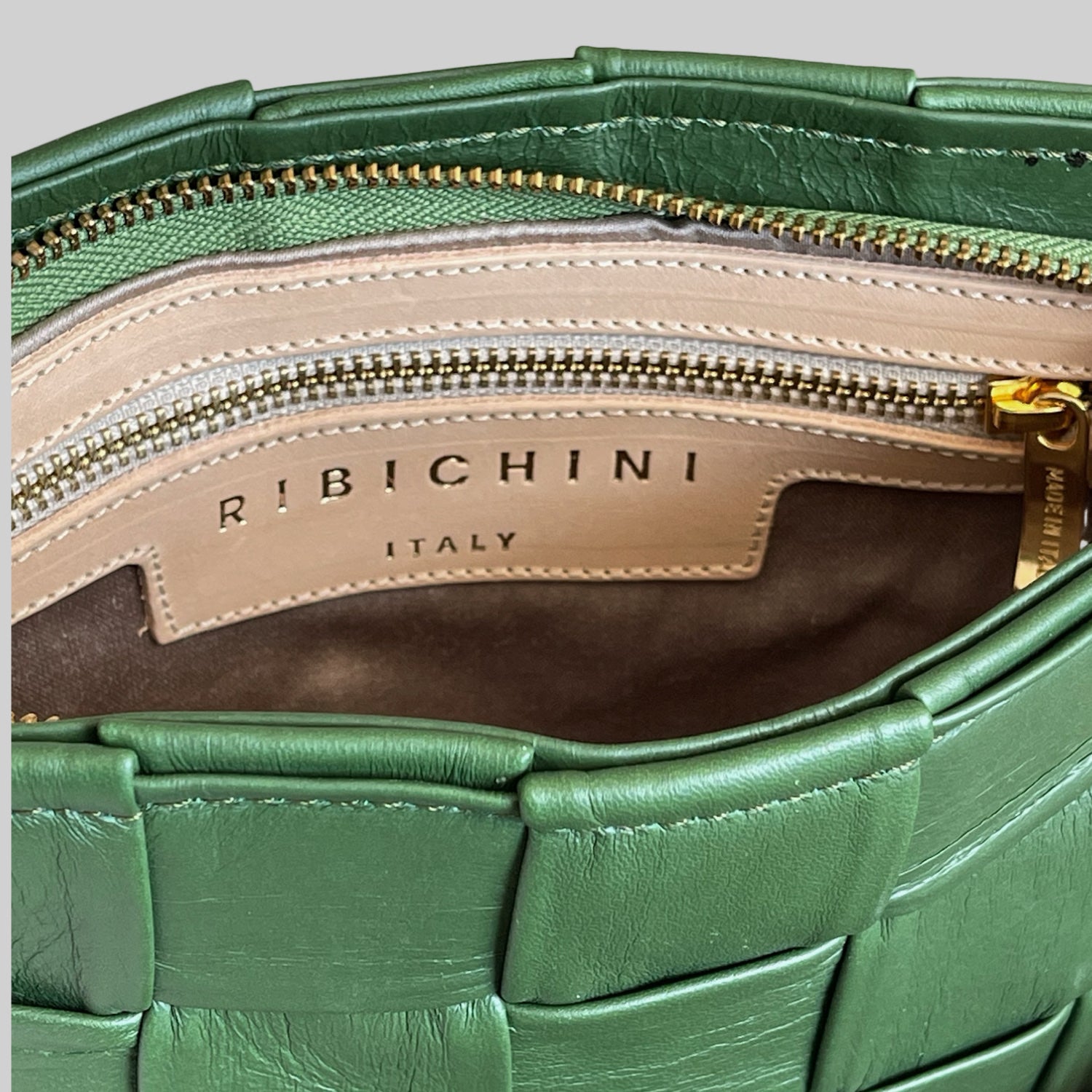 Innsiden av Ribichini Square Clutch i grønn avslører den organiserte designen med en innvendig glidelåslomme.