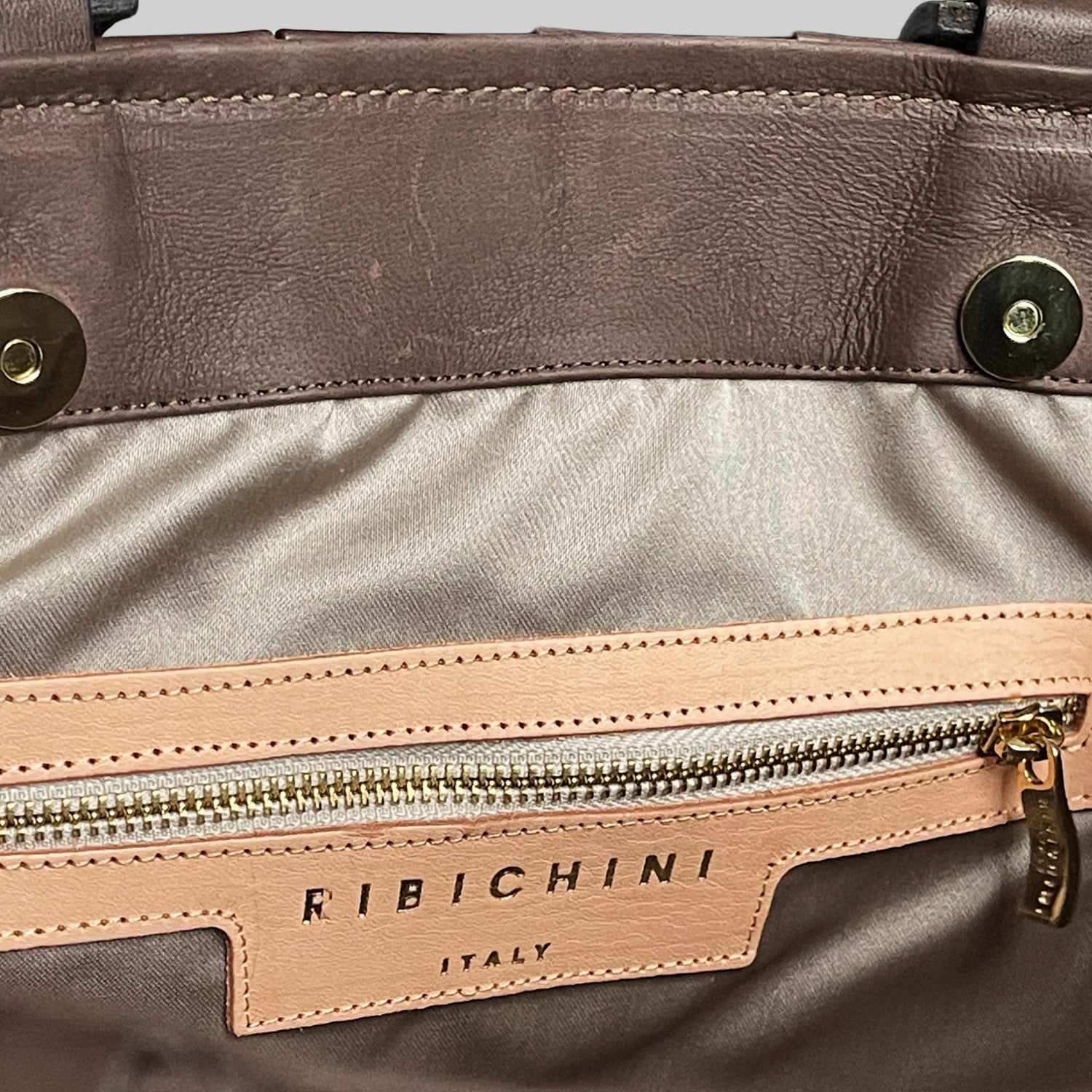 Innsiden av Ribichini Square skinnveske i brunt: Glidelåslomme i gull, R-logo for luksus. Organisert og elegant.