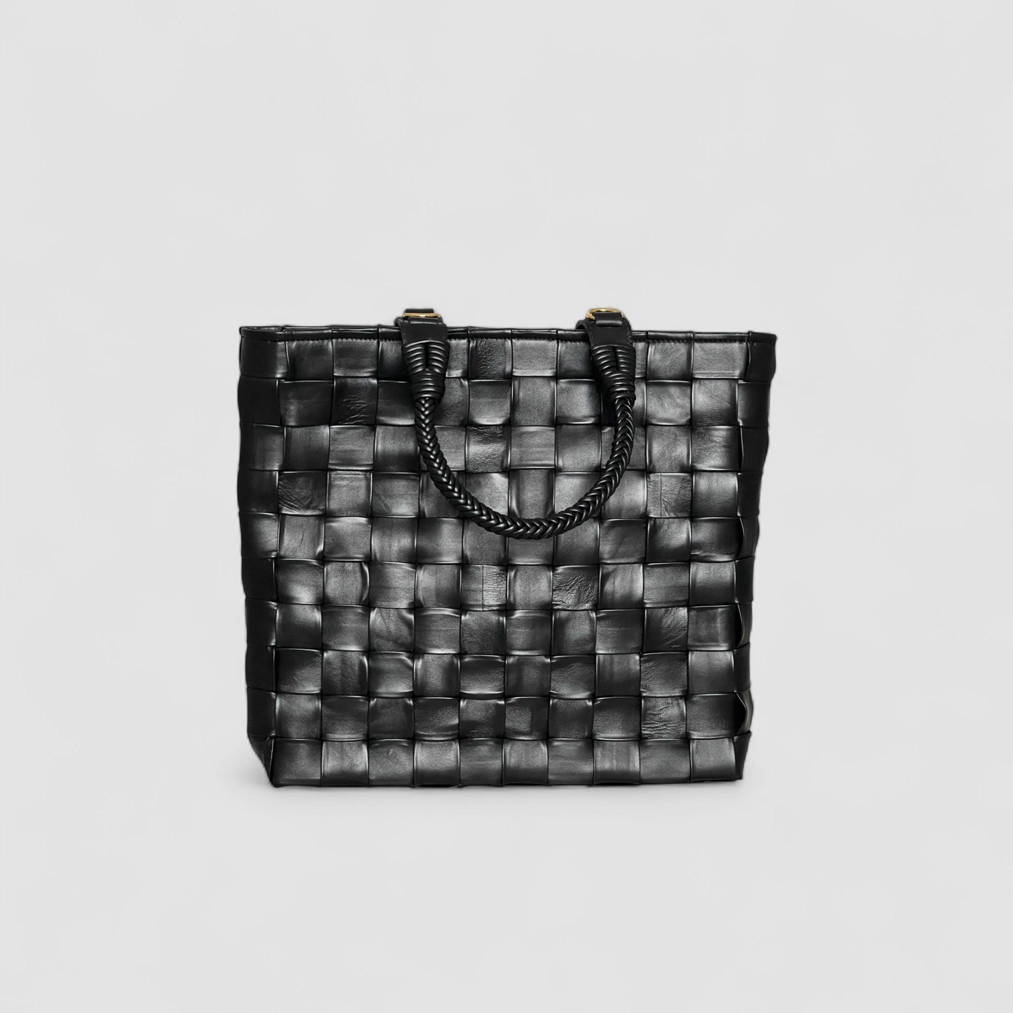 Ribichini Square i sort: Håndlaget lammeskinn med store flettede ruter og elegante hanker.