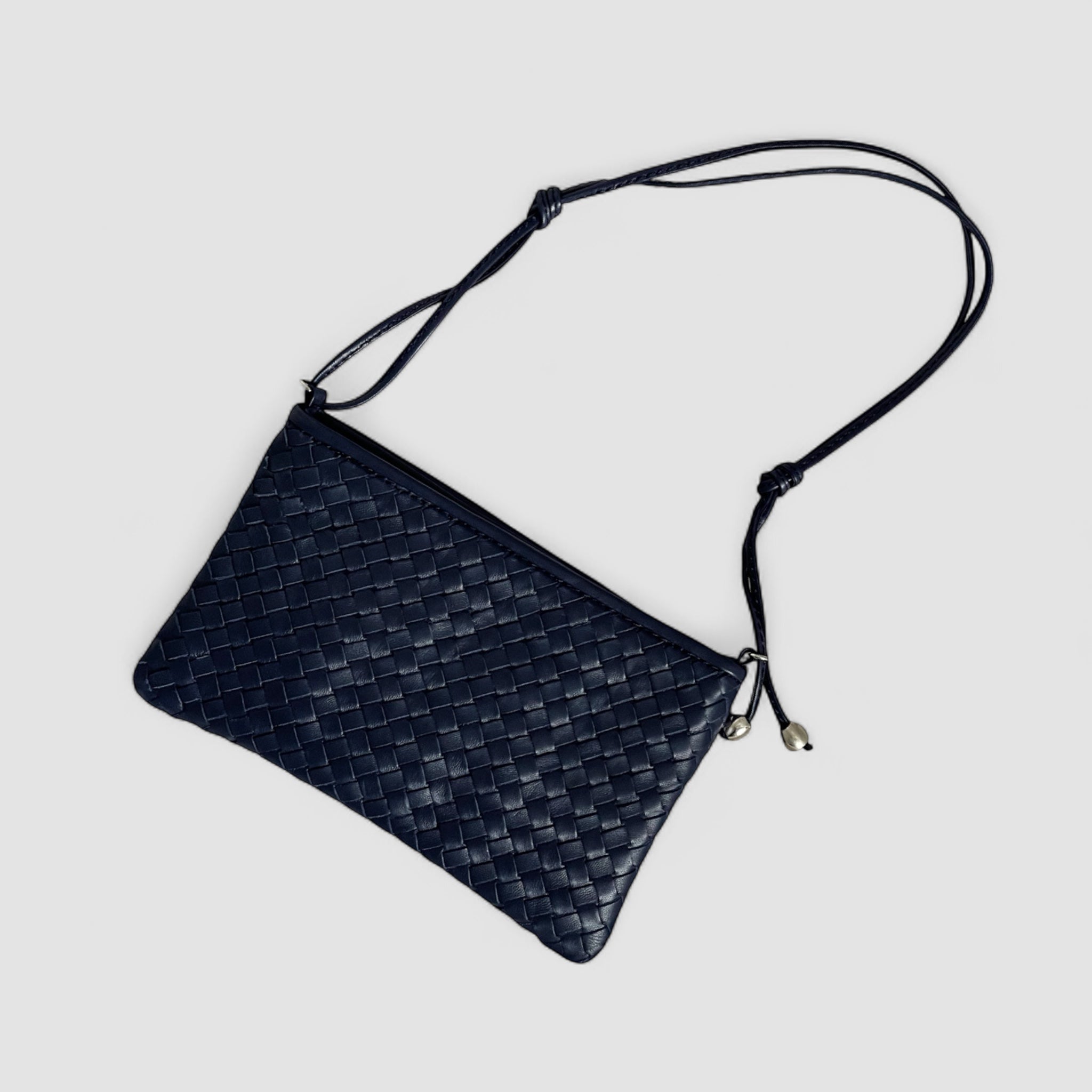 Navyblå flettet clutch i lammeskinn med justerbar skulderrem og sølvkuler – italiensk eleganse fra Ribichini.