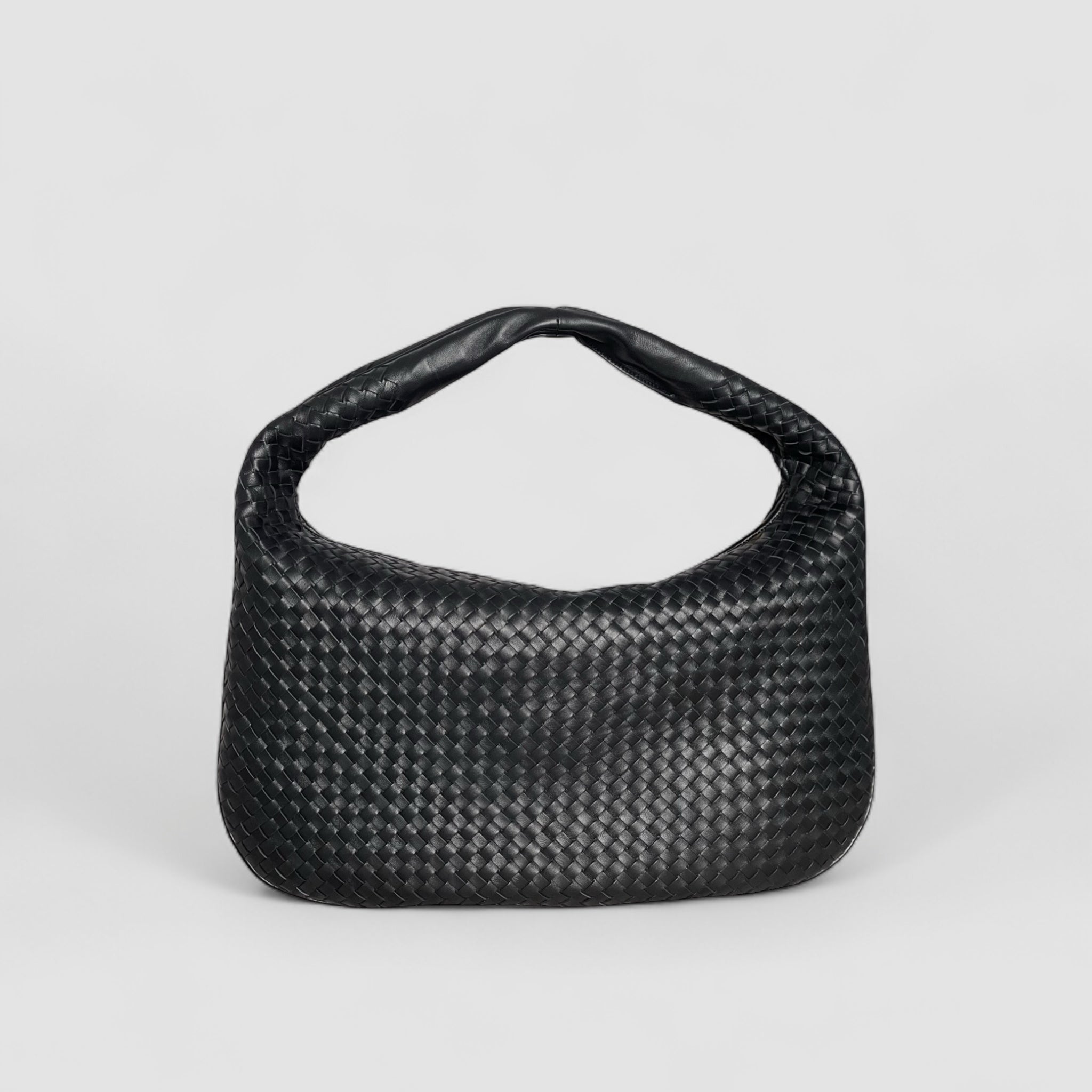 Sort Ribichini Isola skinnveske med flettet design laget av lammeskinn, viser elegant form og håndtak.