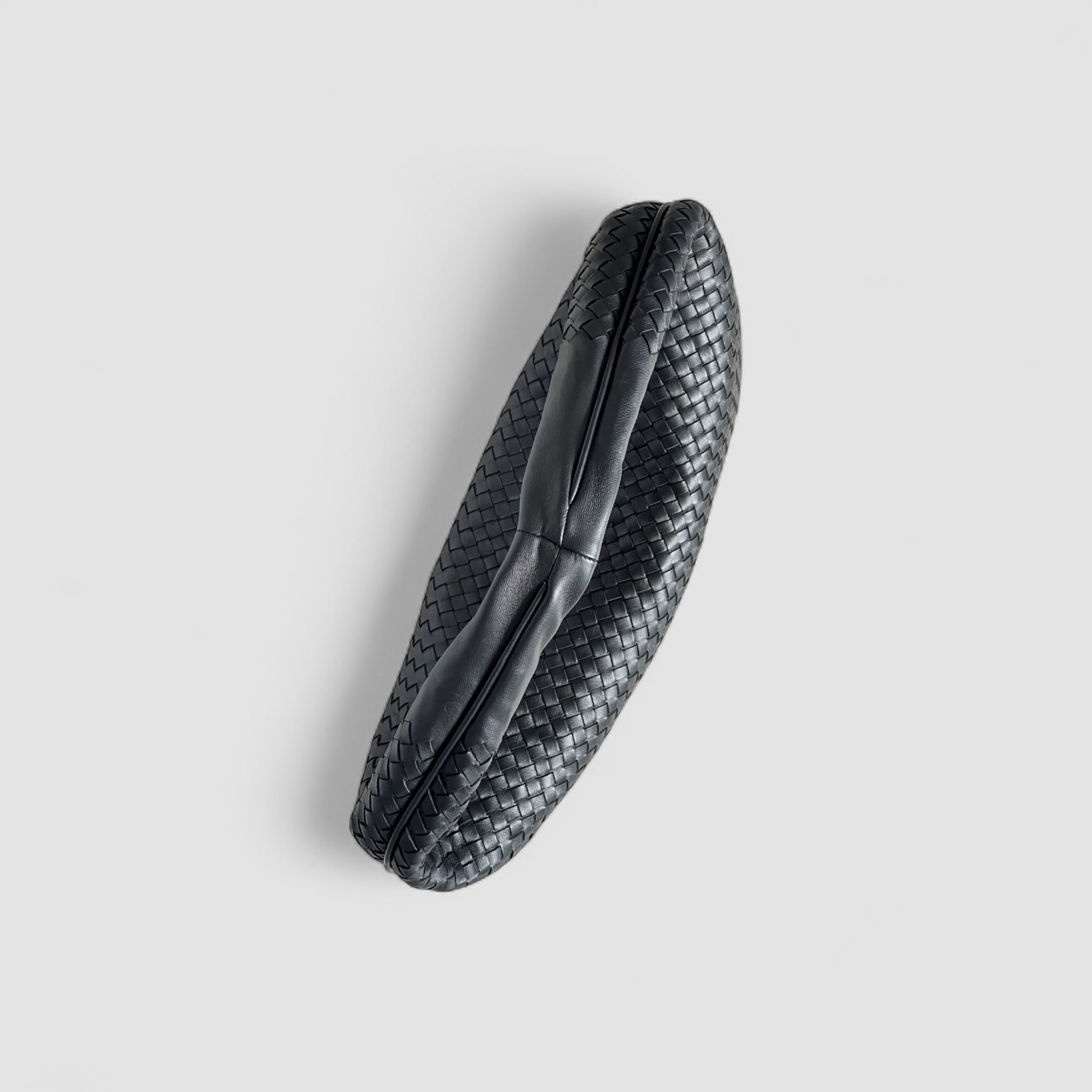 Toppvisning av Ribichini Isola veske i sort med flettet design og glatt skulderstropp.