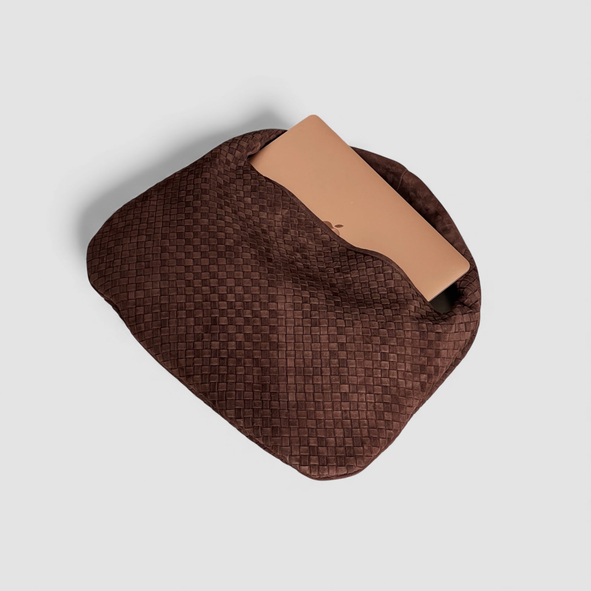 Ribichini Isola Royal semsket flettet skinnveske i chocolate, med plass til en bærbar datamaskin som stikker opp fra vesken.