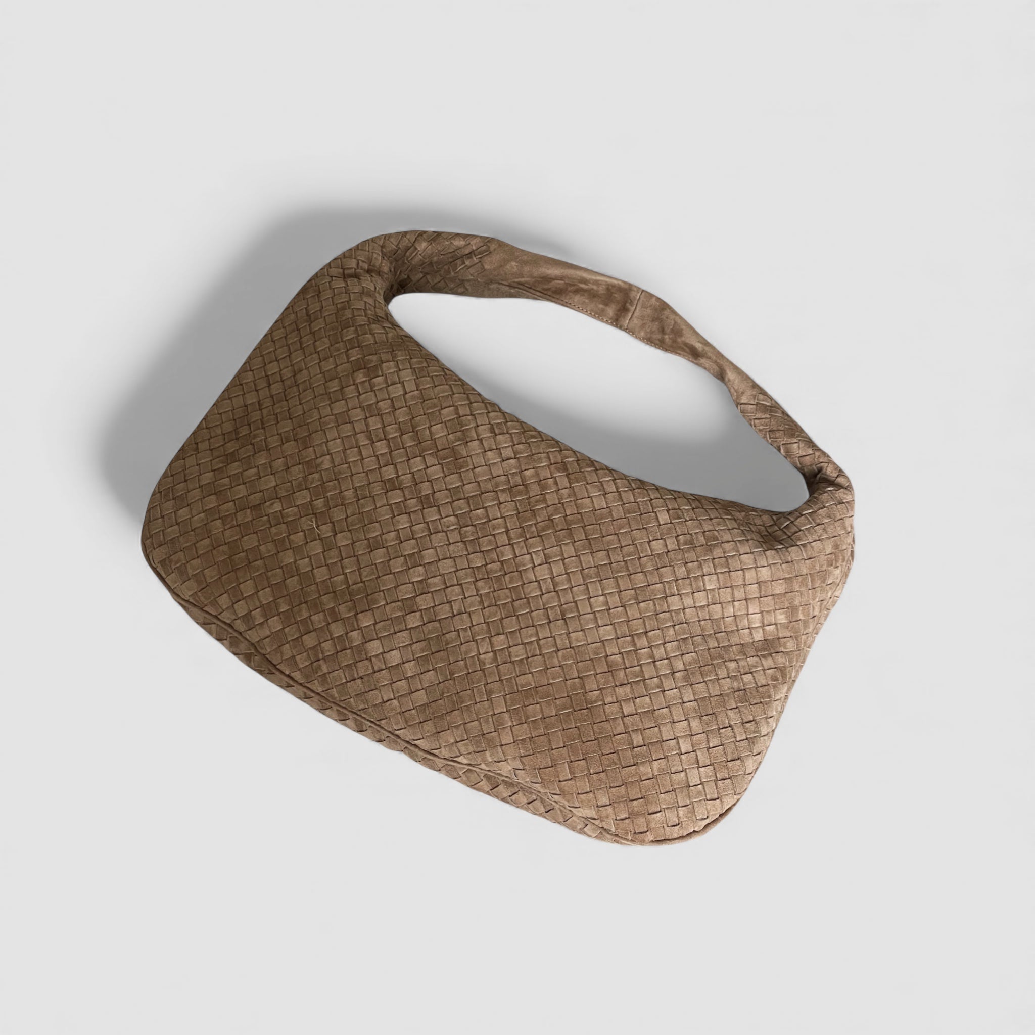 Bird's-eye view av Ribichini Isola royal semsket skinnveske i fargen terra, fremviser det flettede designet og den kurvede formen.