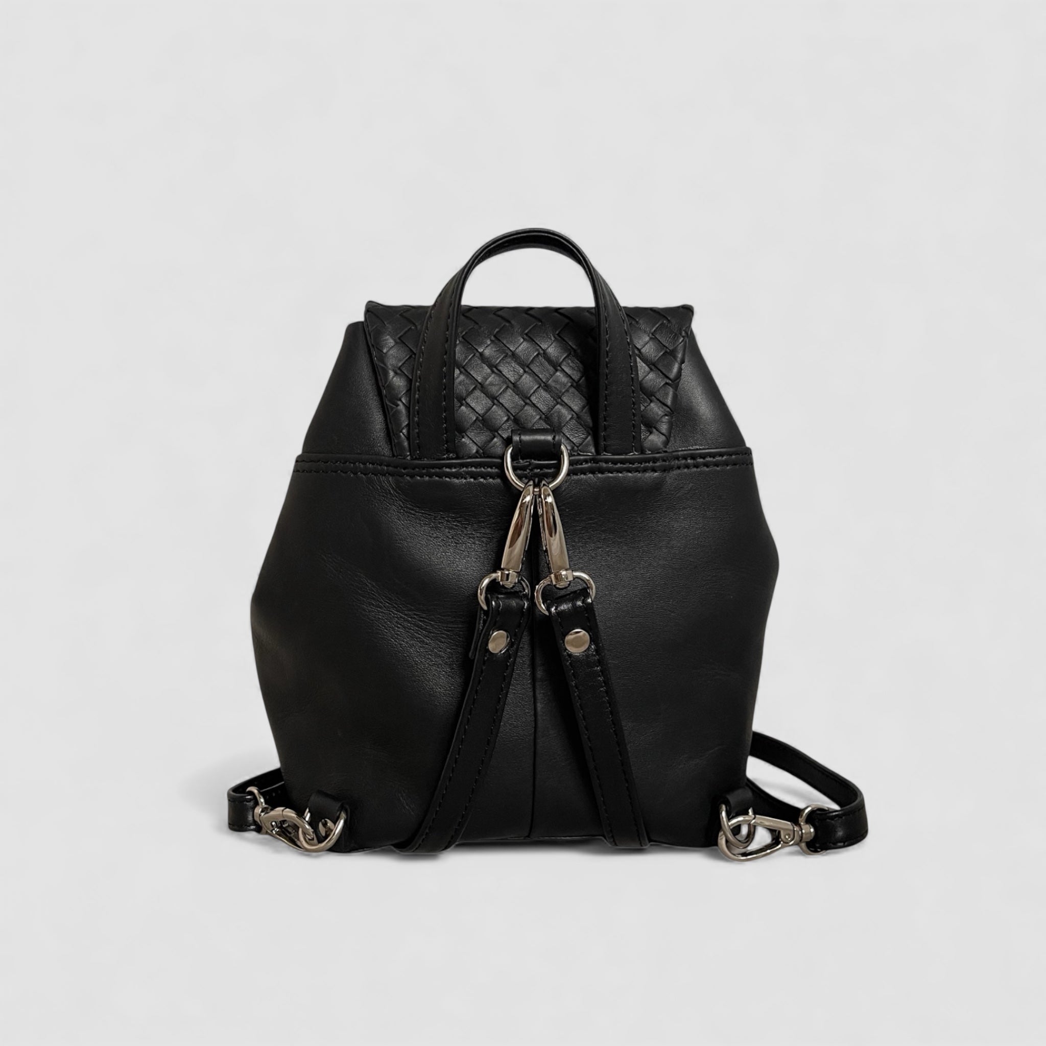Ribichini Backpack Mini sett bakfra, i glatt og håndflettet svart skinn med justerbare skulderremmer og sølvfargede detaljer.