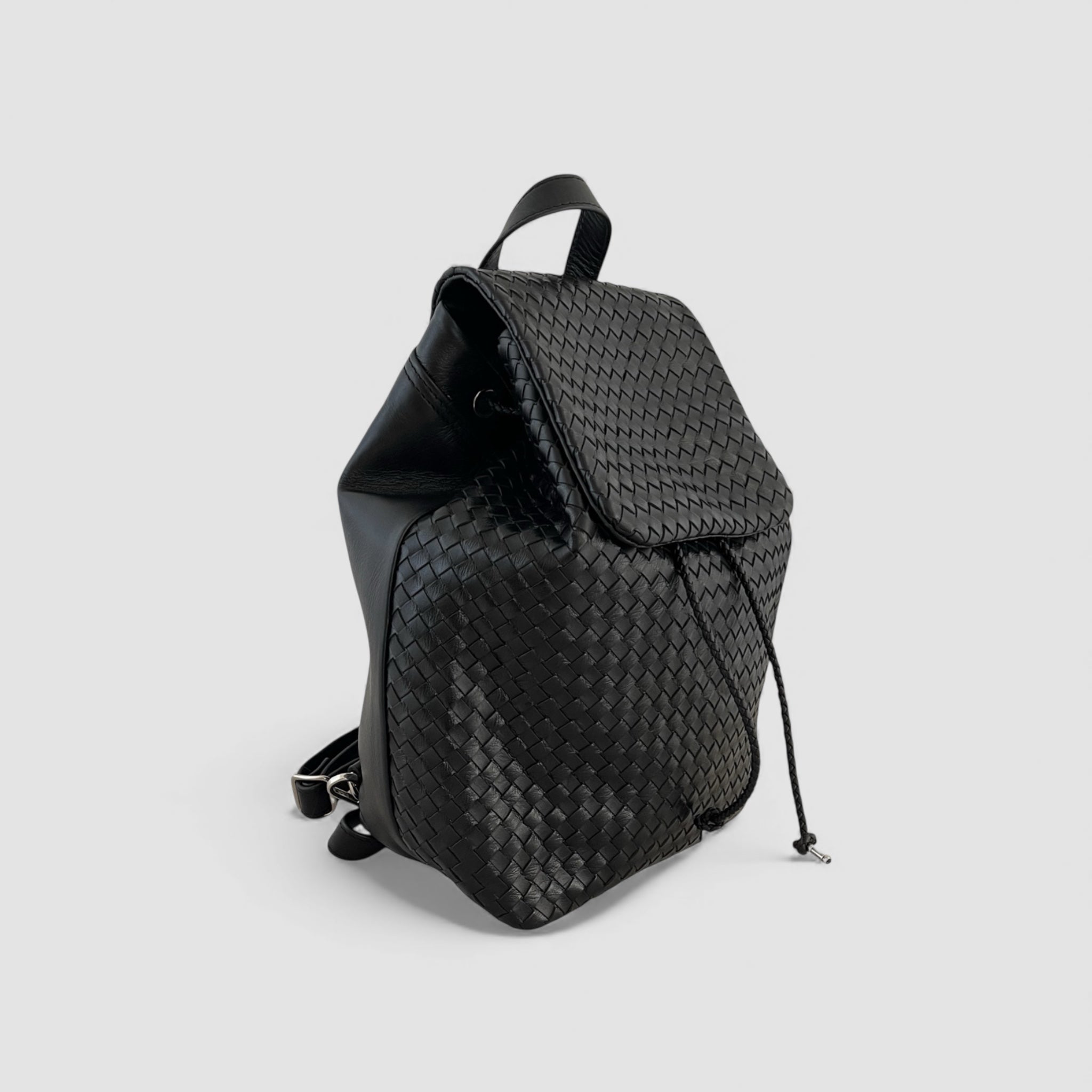 Ribichini Backpack Large i svart håndflettet italiensk skinn, sett fra siden med snøring og klassisk klaff.