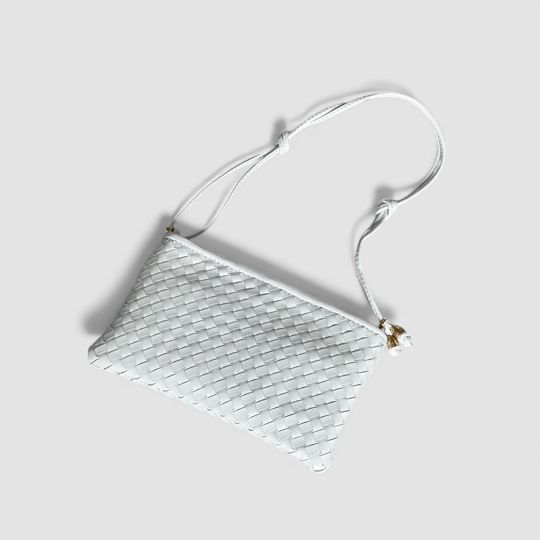 Hvit Camper Clean clutch i håndflettet skinn med justerbar skulderrem og gullfargede detaljer.