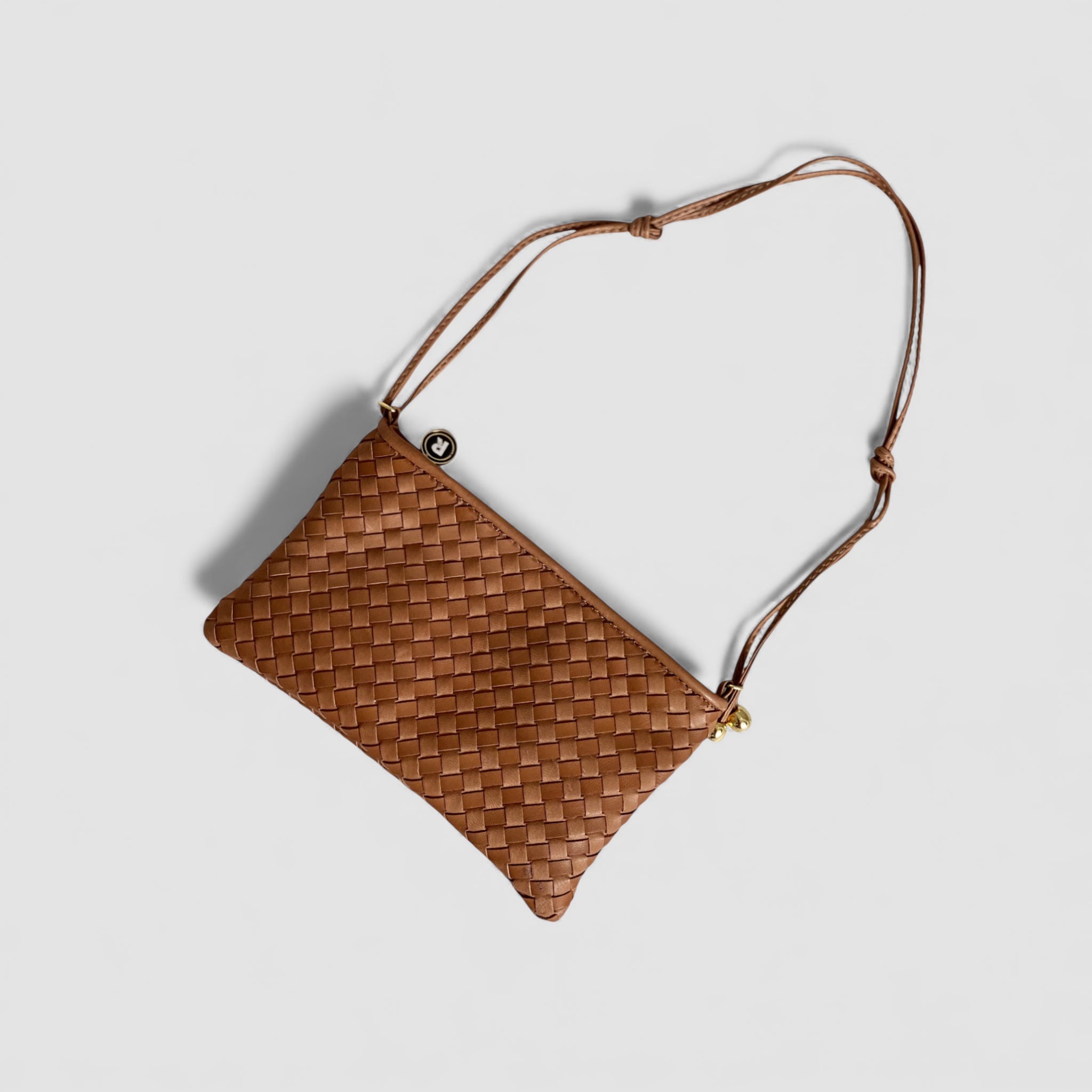 Ribichini Camper Clean Clutch i Cognac i en liggende posisjon, og gir et detaljert innblikk i veskens fine detaljer.