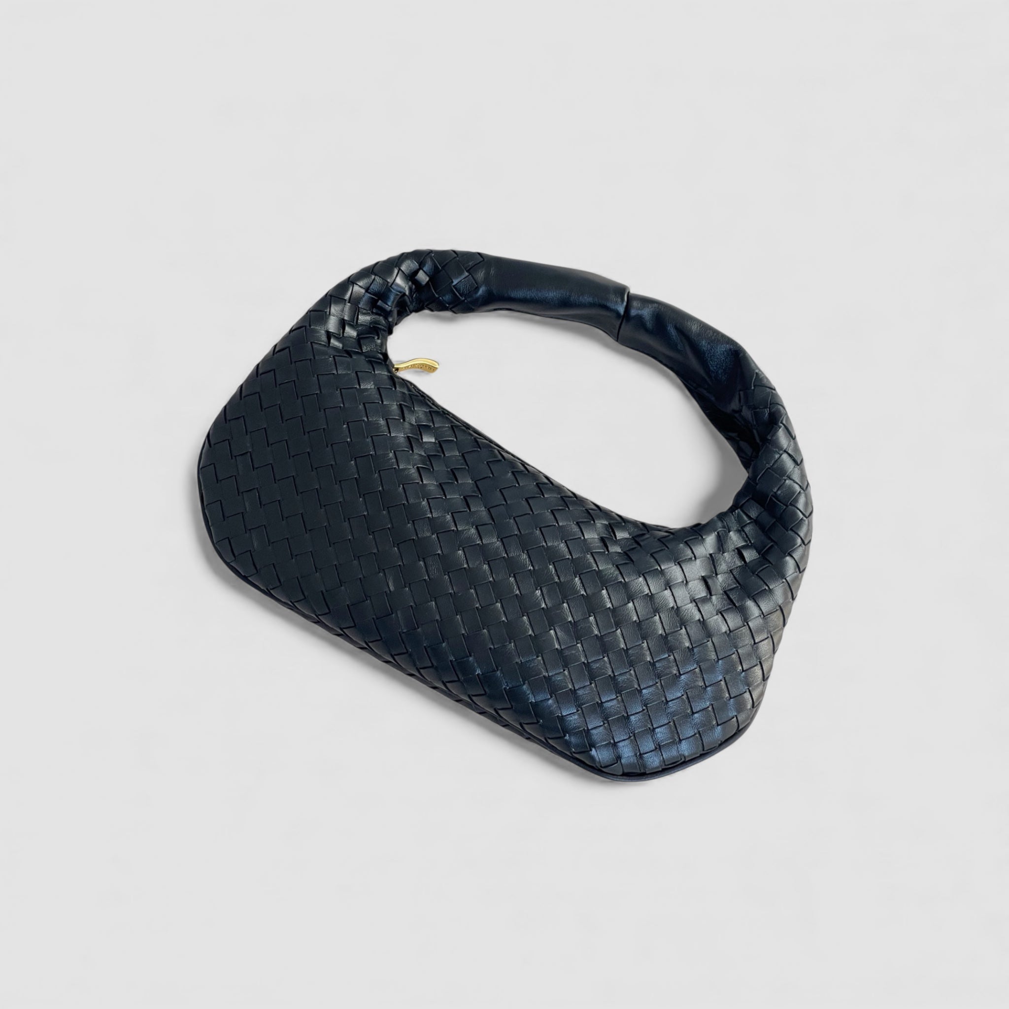 Ribichini Isola Bella i sort flettet skinn med avrundet design og gullglidelås, laget av mykt lammeskinn for en luksuriøs look.