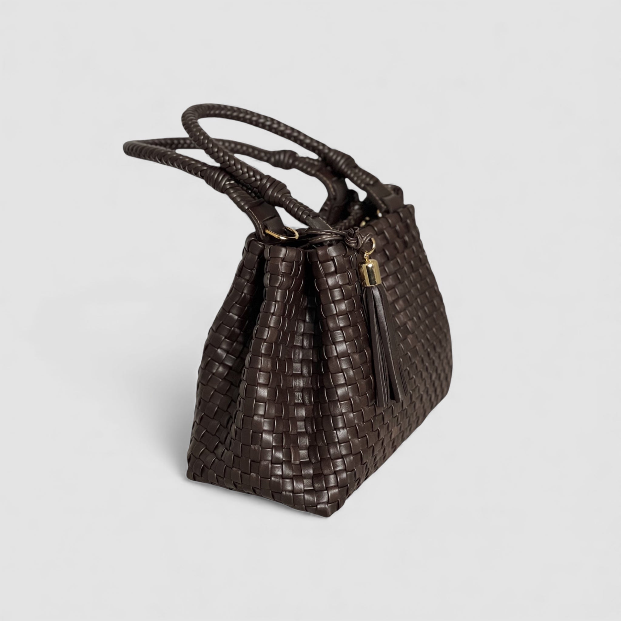 Siden av "Sophia" skinnvesken i dyp sjokoladefarge viser de vakre flettede hankene som utstråler håndverksmessig kvalitet og eleganse.