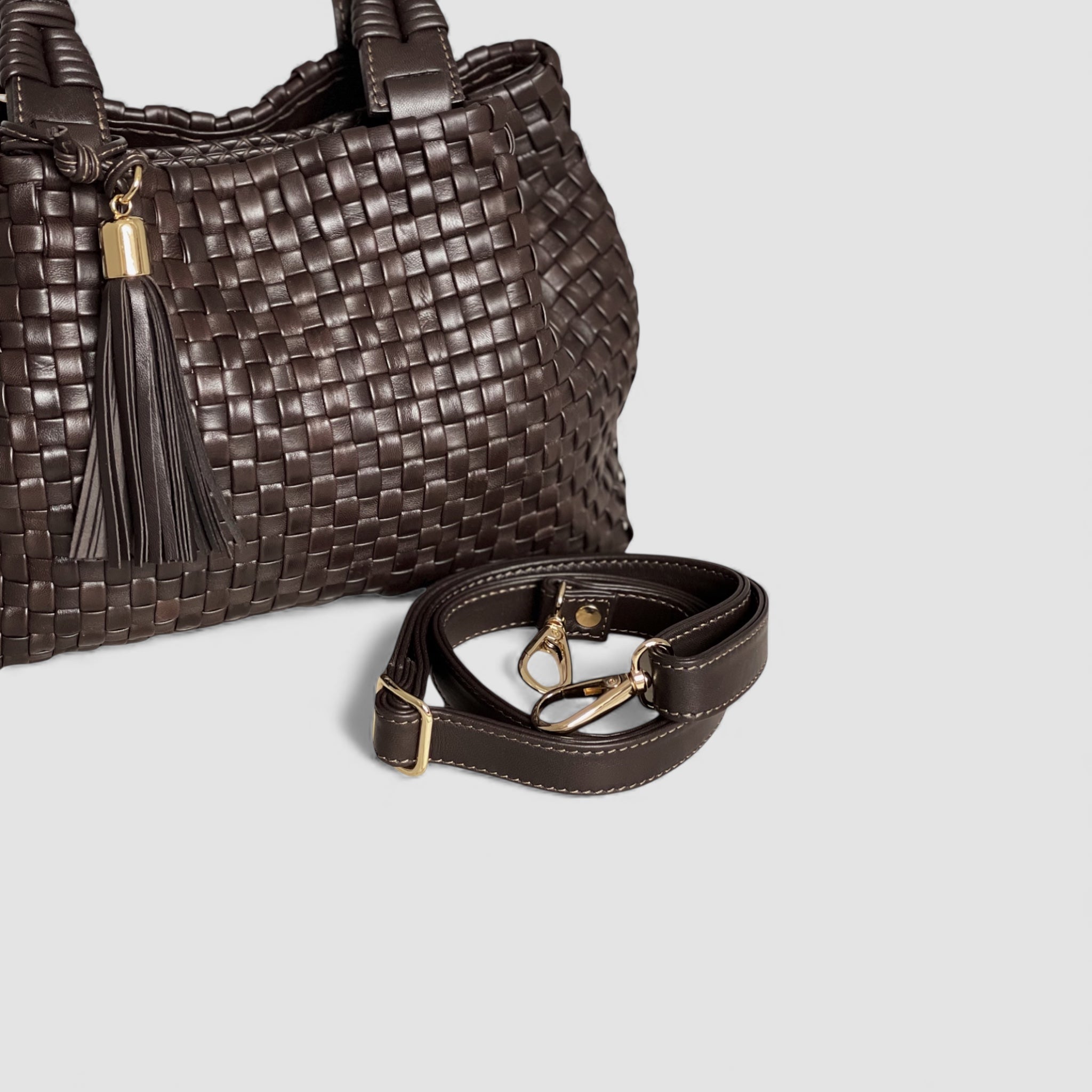 Bildet viser en sjokoladefarget skulderstropp med elegante gulldetaljer, et luksuriøst tilbehør som kompletterer "Sophia" vesken.