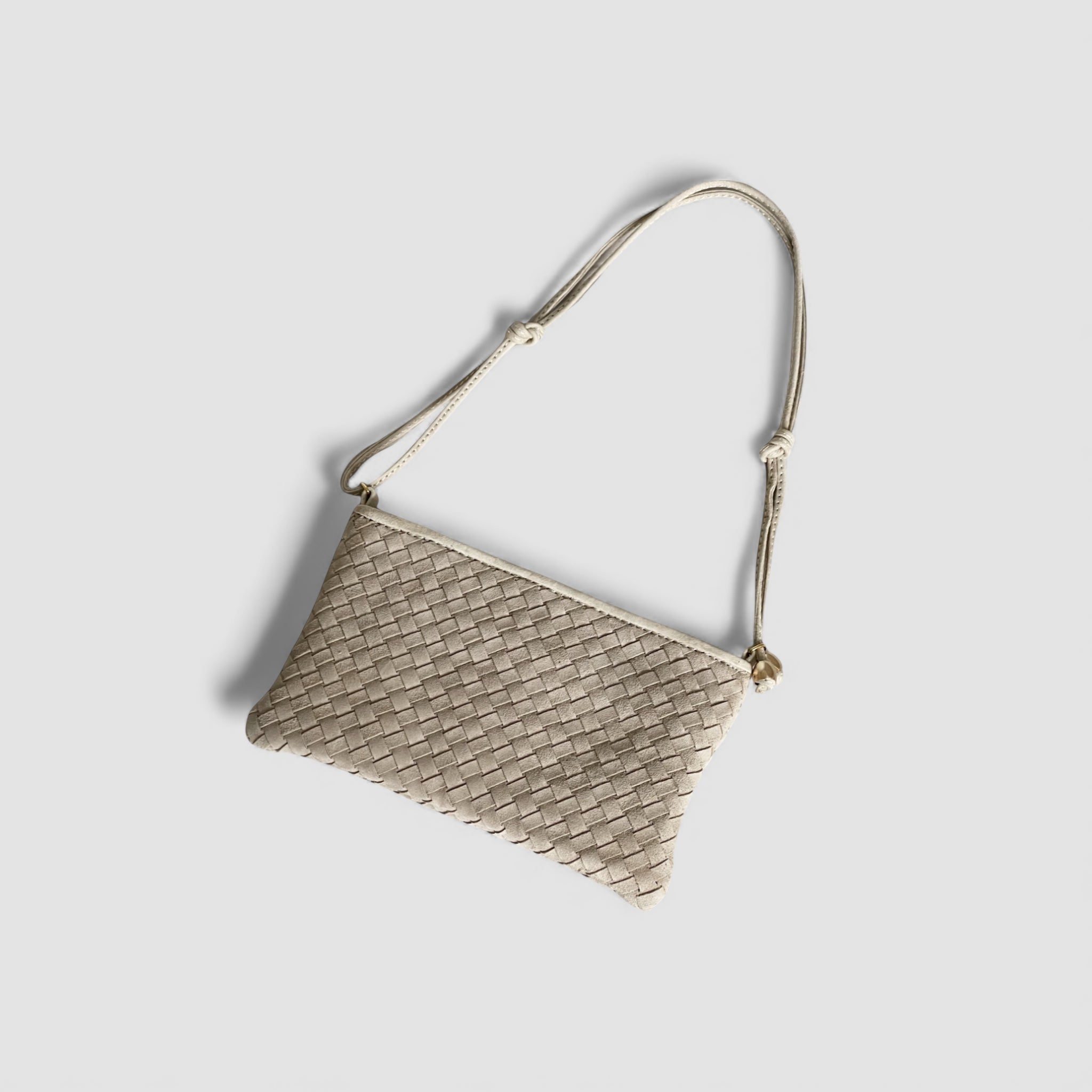 Ribichini Camper clutch i fargen sand i semsket lammeskinn med flettet design og gulldetaljer, vist ovenfra med skulderrem.