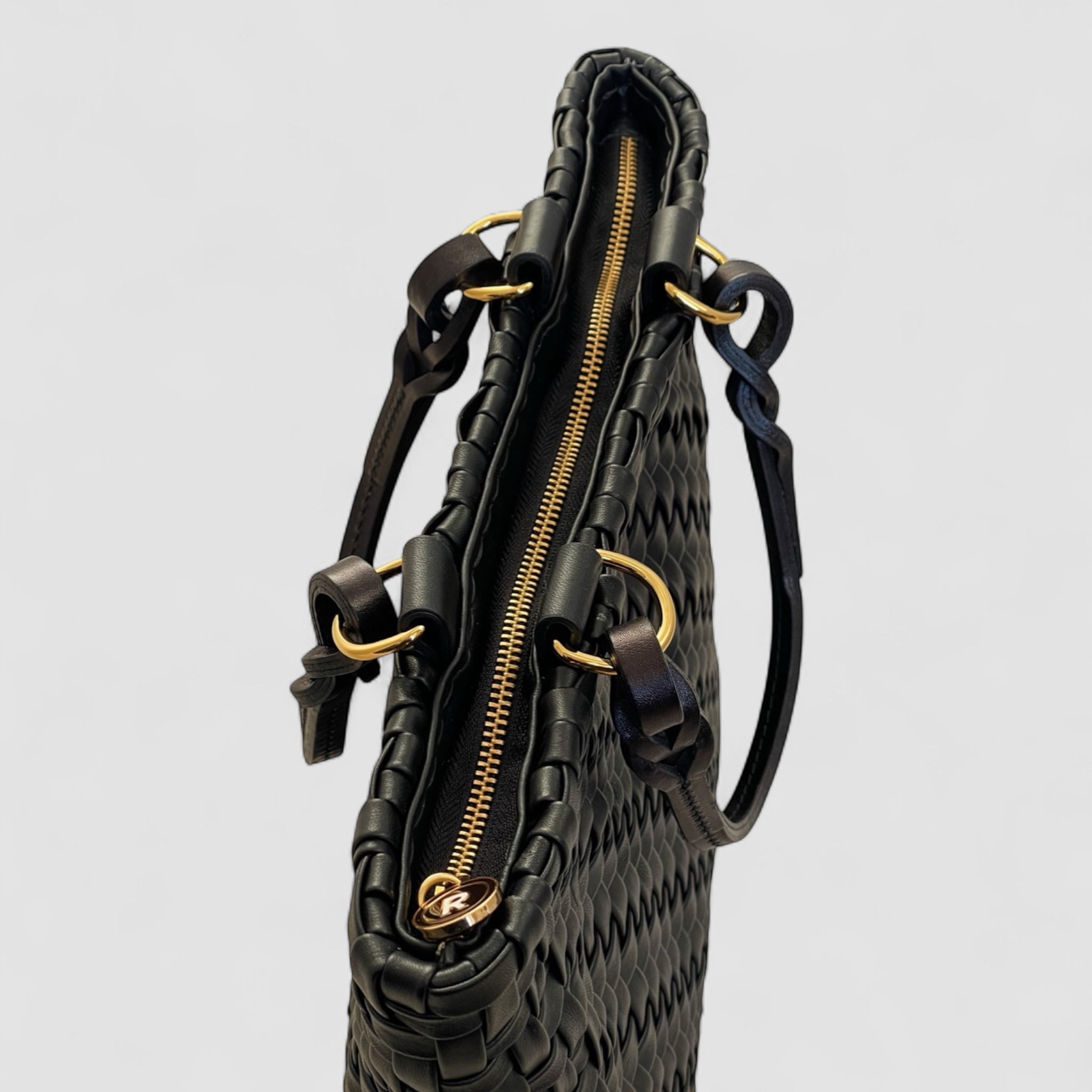 Ribichini Safari Lady-vesken i sort, med flettet lammeskinn og glidelås, kombinerer stil og funksjonalitet på en elegant måte.