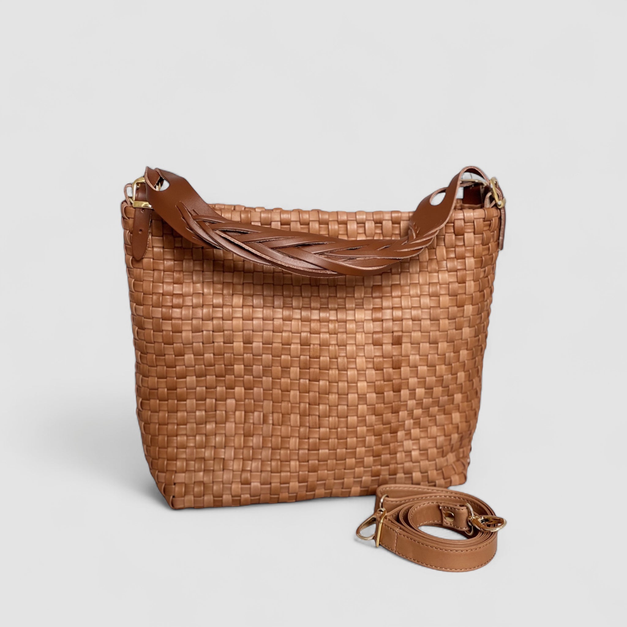 Bær Ribichini Camper-vesken i cognac over skulderen for frie hender. De gyldne detaljene på skulderstroppen legger til luksus og stilsikkerhet.