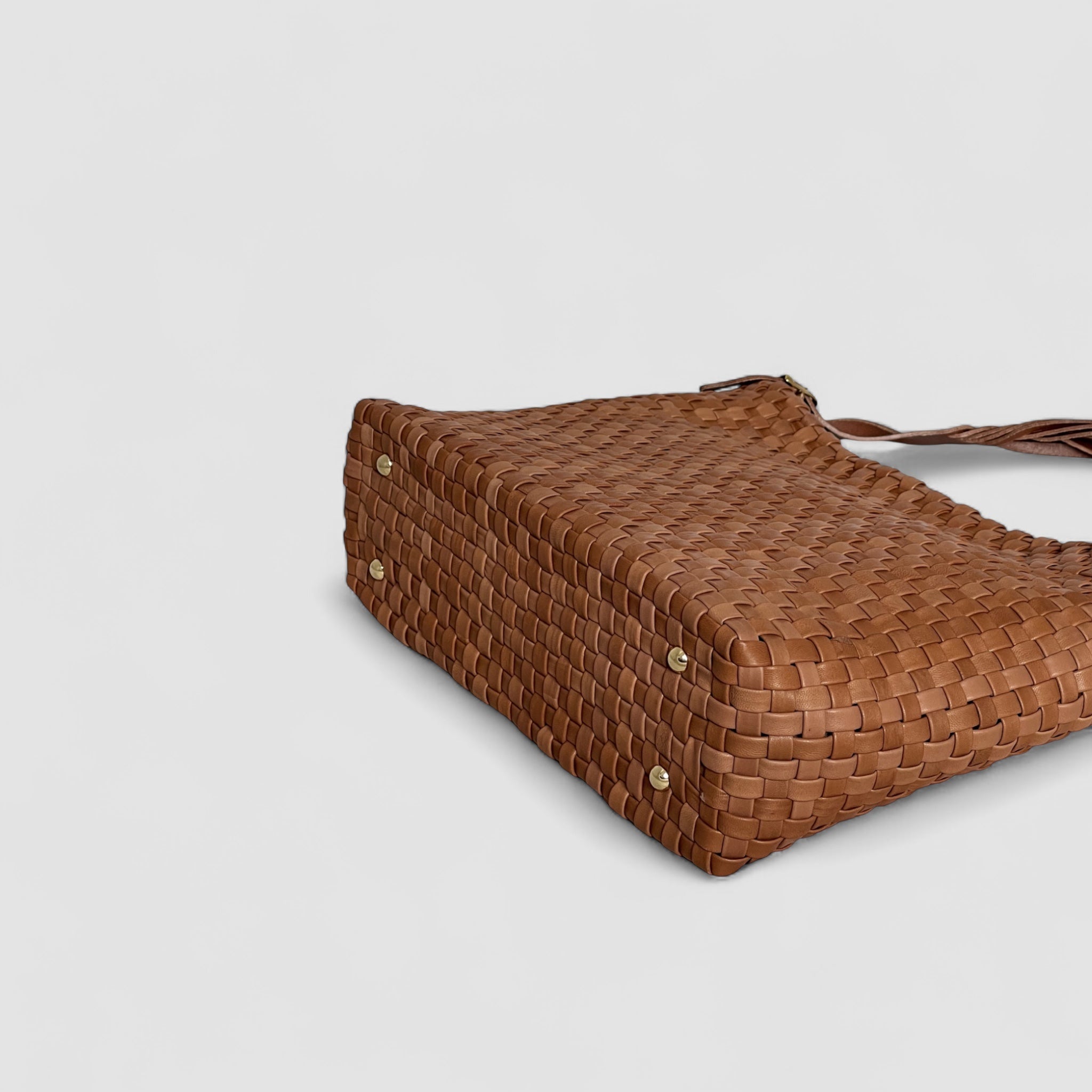 Ribichini Camper Clean vesken i cognac, liggende, fremhever sin elegante form og rike farge. Gullknoppene gir funksjonalitet og luksus.