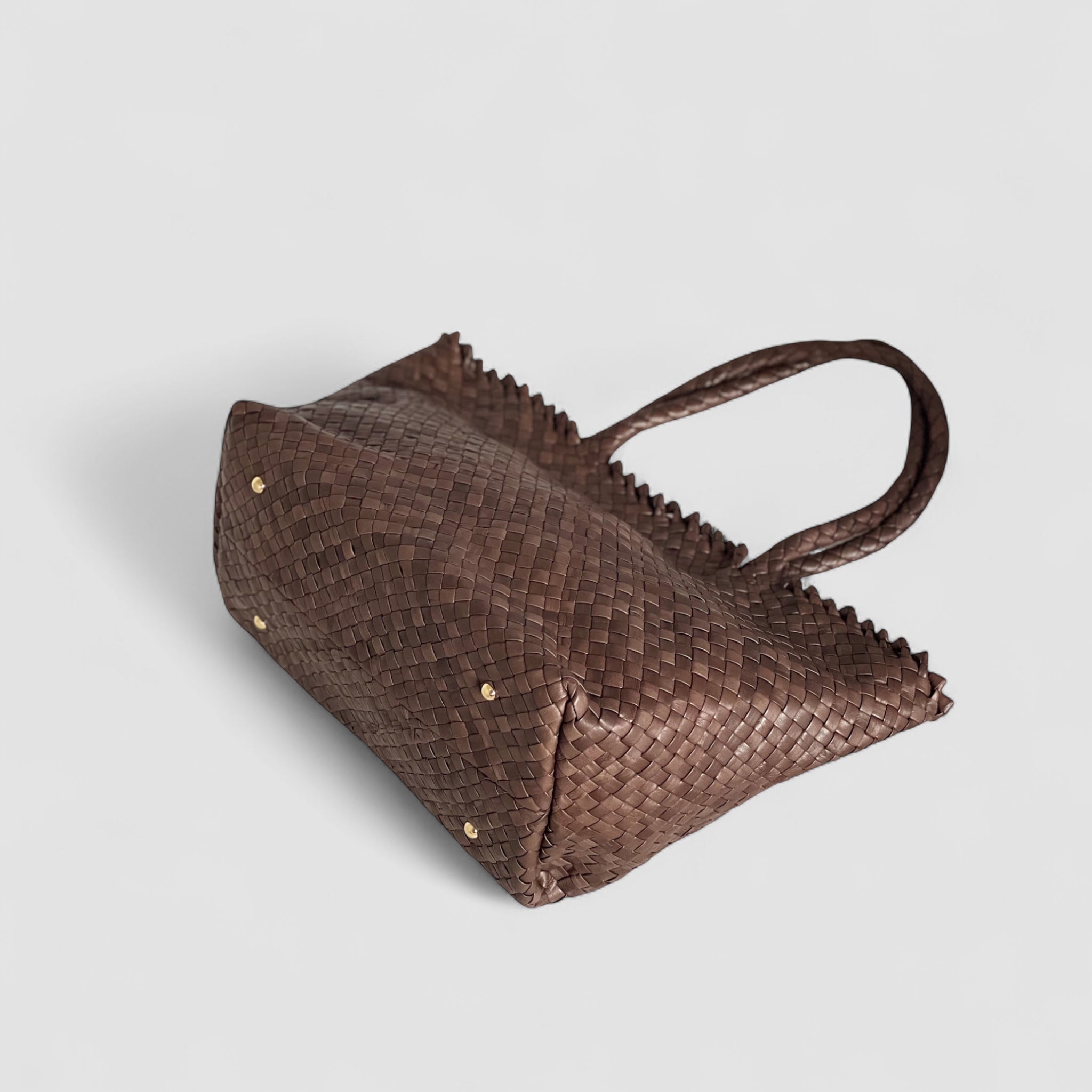 Ribichini Woodstock Classic skinnveske i brunt ligger elegant med gullknotter og unikt flettemønster i lammeskinn.