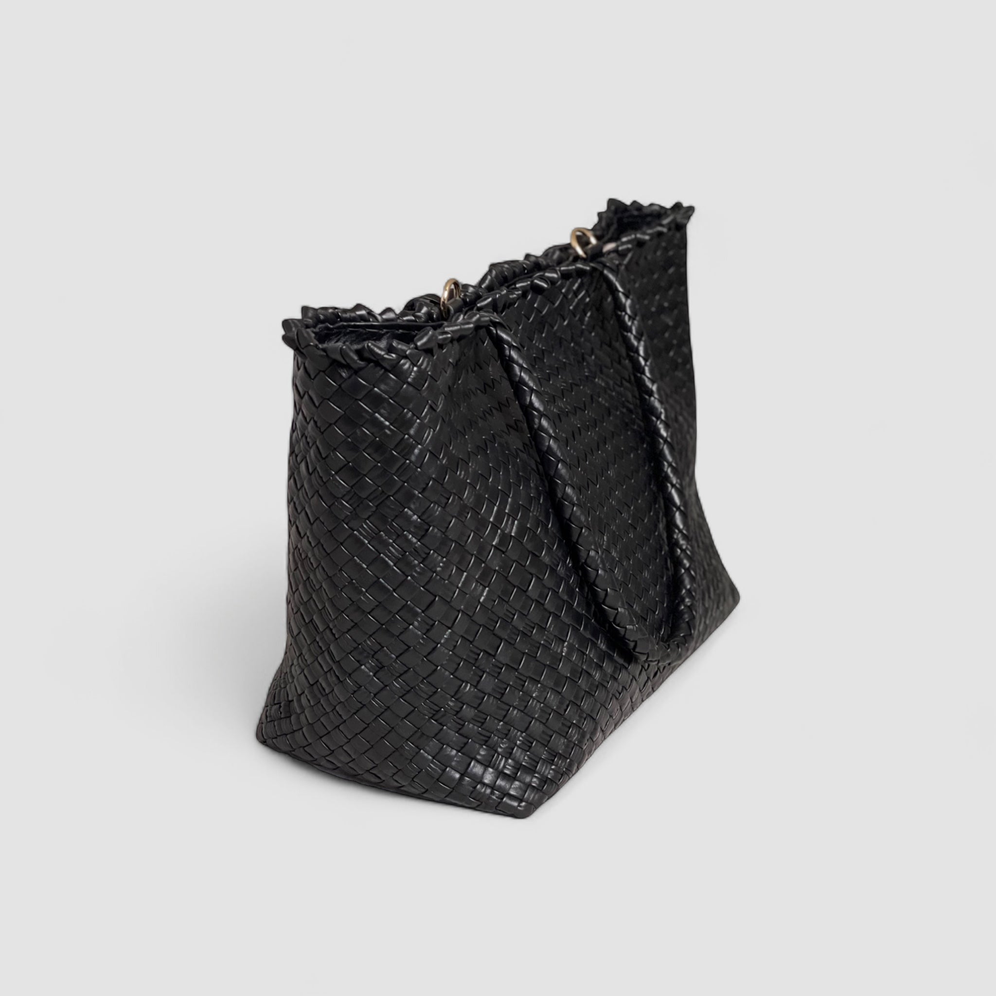 Sidevisningen av Ribichini Woodstock Classic-vesken i sort fremhever den detaljerte flettingen i lammeskinnet og de glitrende gulldetaljene.