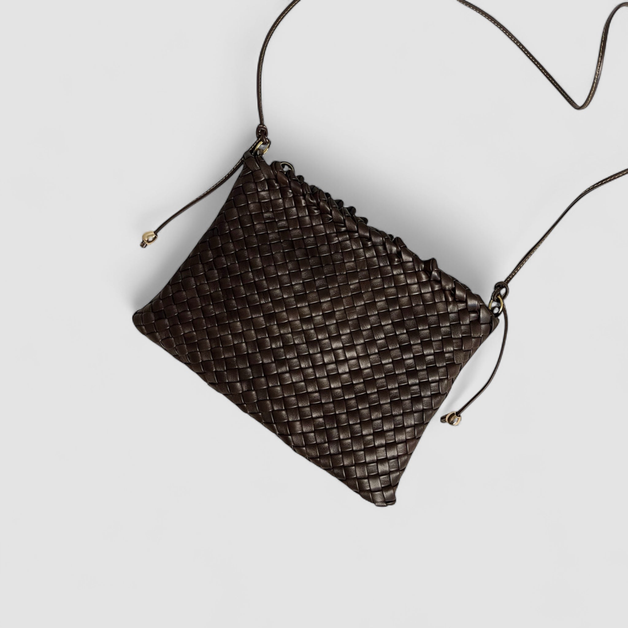 Ribichini Woodstock-clutch i sjokoladebrunt flettet lammeskinn. Tydelig flettemønster, justerbar skulderrem for komfortabel bruk.