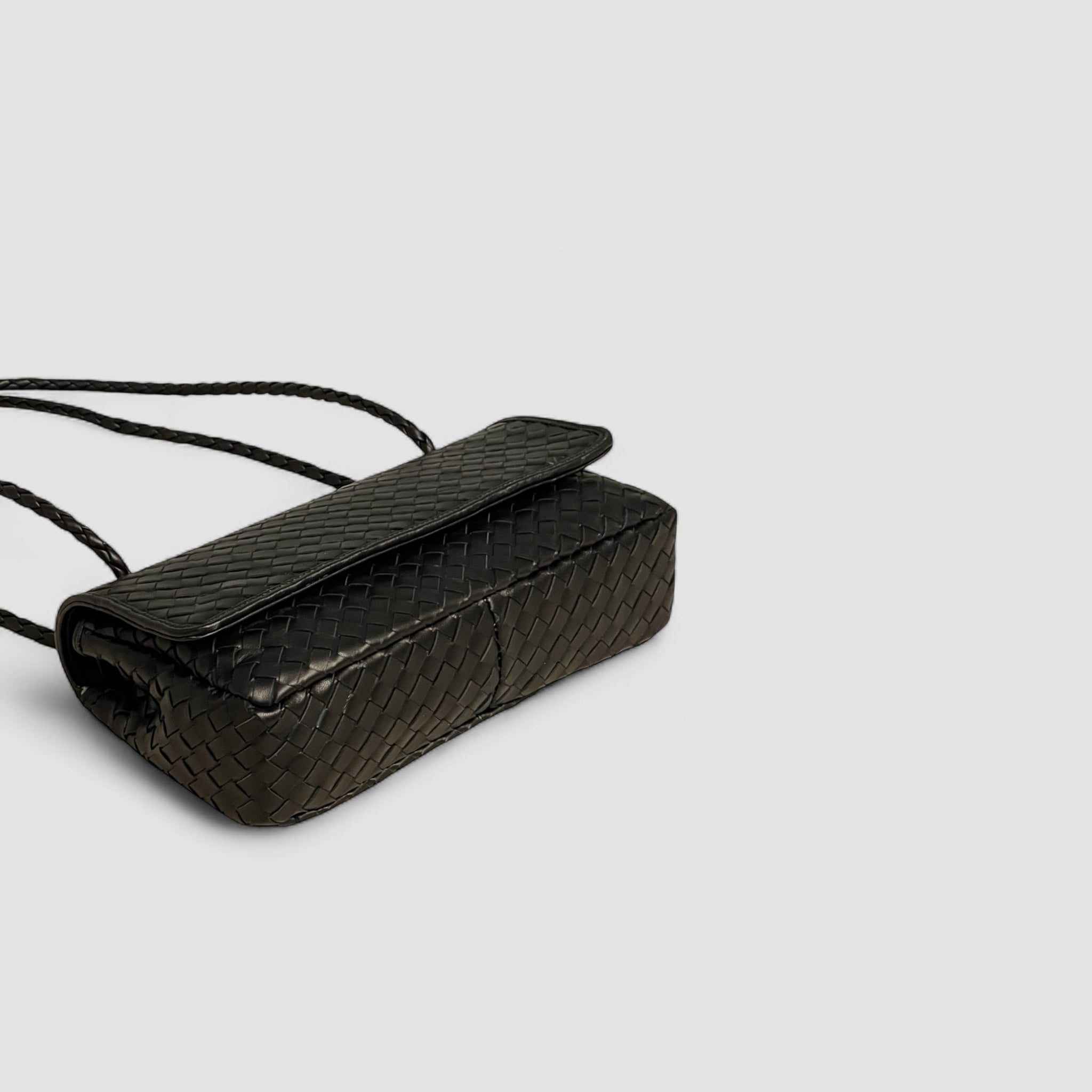 Bildet viser Ribichini Envelope-clutchen i liggende format med sort lammeskinn og gull-detaljer.