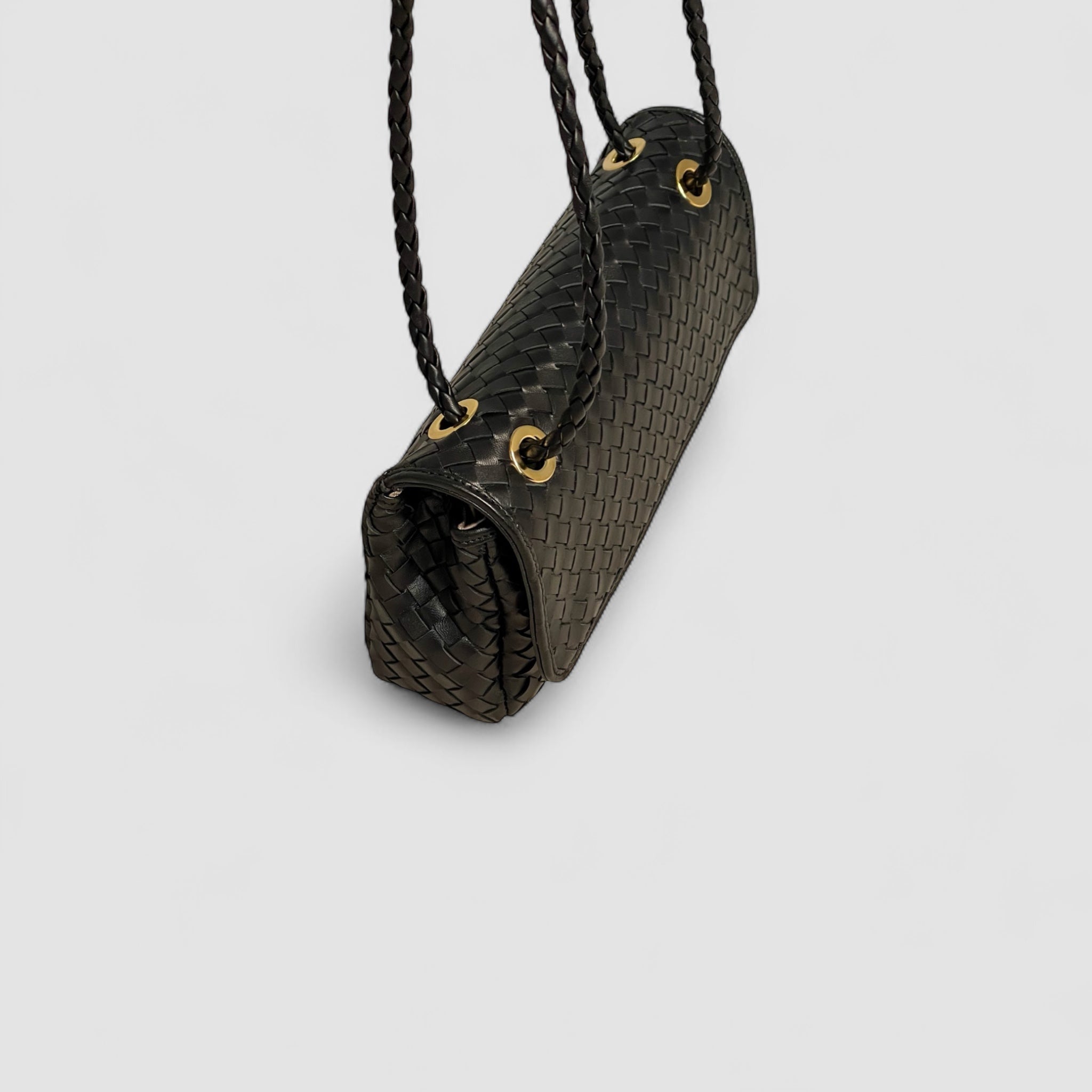Bildet viser detaljert fugleperspektiv av justerbare, flettede skinnhanker på Ribichini Envelope-clutchen.