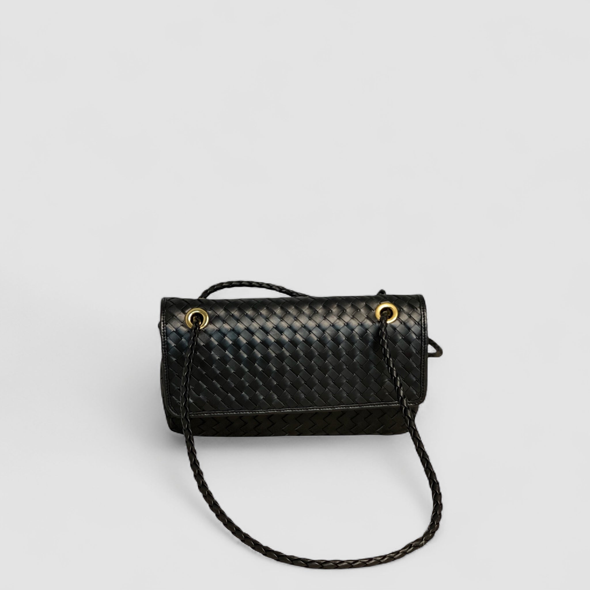 Bildet viser Ribichini Envelope-clutchen forfra, flettet i sort mykt lammeskinn med gull-detaljer.