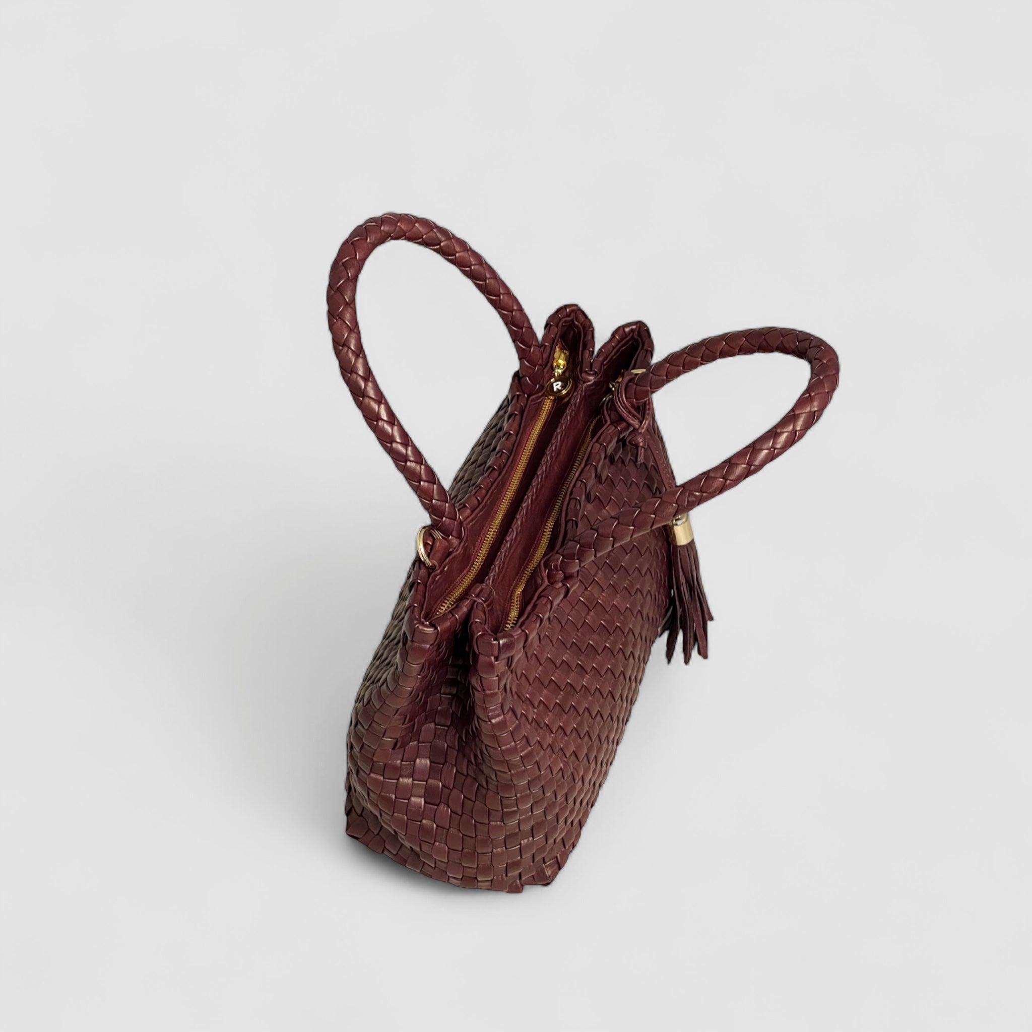 Ribichini Ginny-skinnvesken gir god organisering med to glidelåslukkede rom, mens de elegante gulldetaljene legger til en luksuriøs følelse og raffinement