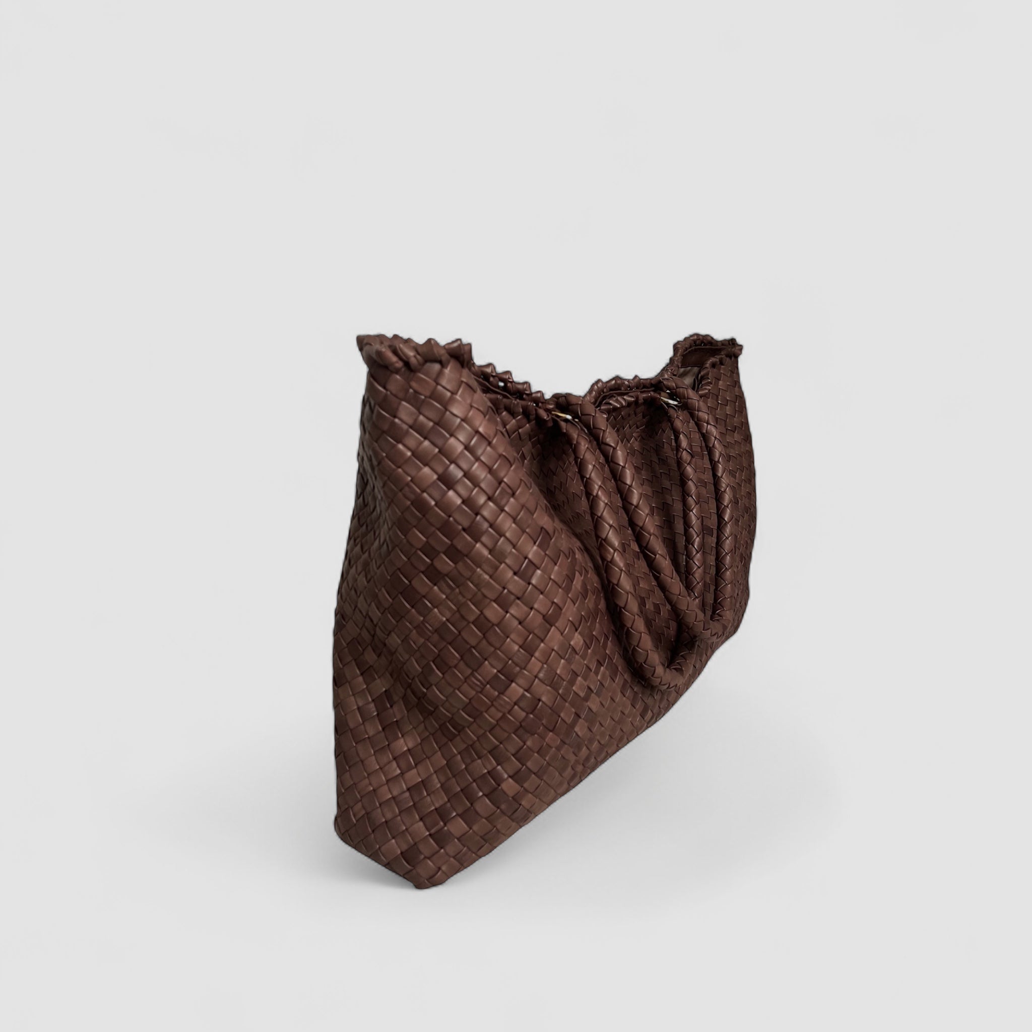 En brun Ribichini Woodstock weekend-veske med håndflettet lammeskinn og gullfargede detaljer. Den er praktisk og elegant for både reiser og daglig bruk.