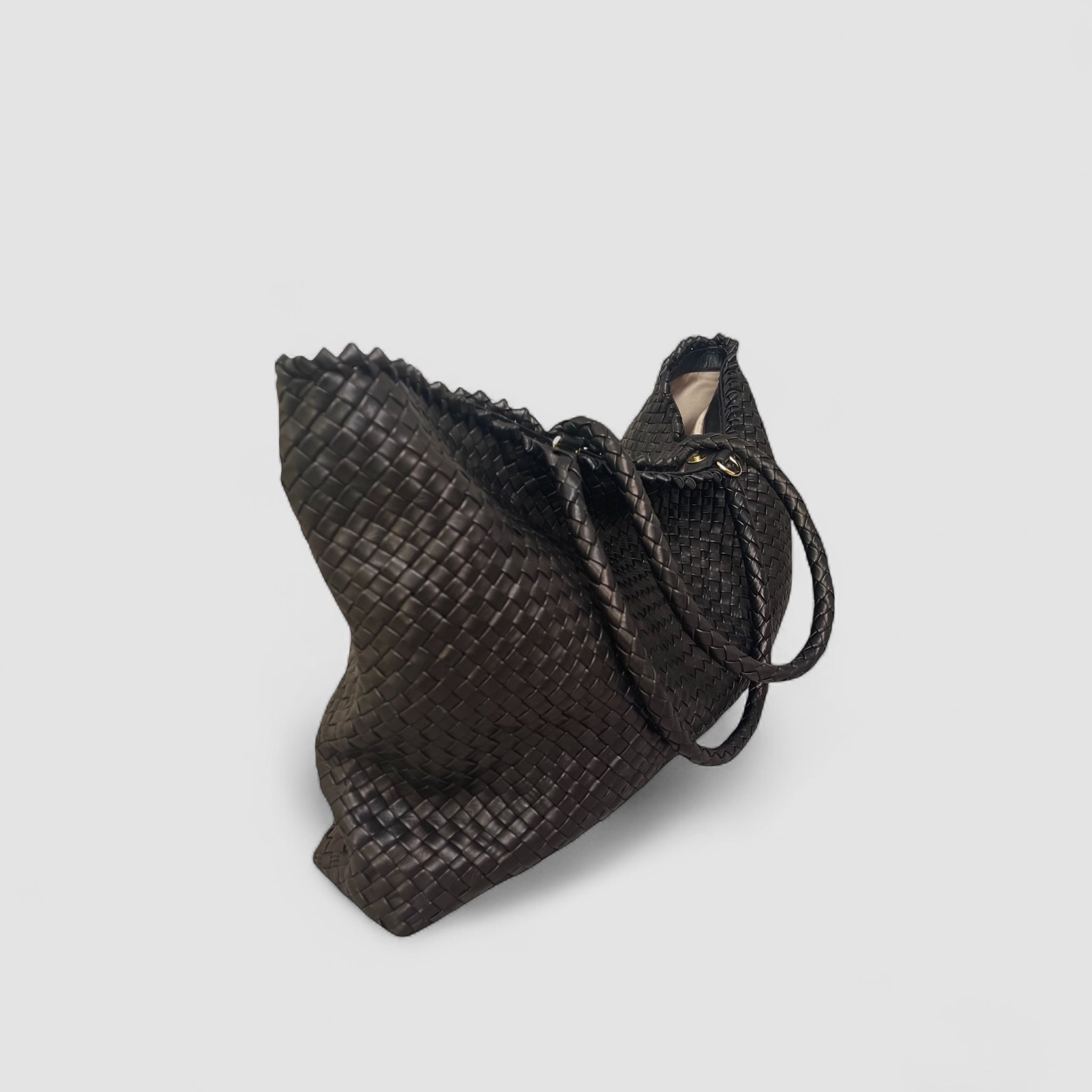 Ribichini Woodstock weekend veske i sort lammeskinn, håndflettet med elegante gullfargede detaljer, perfekt for reise og daglig bruk.