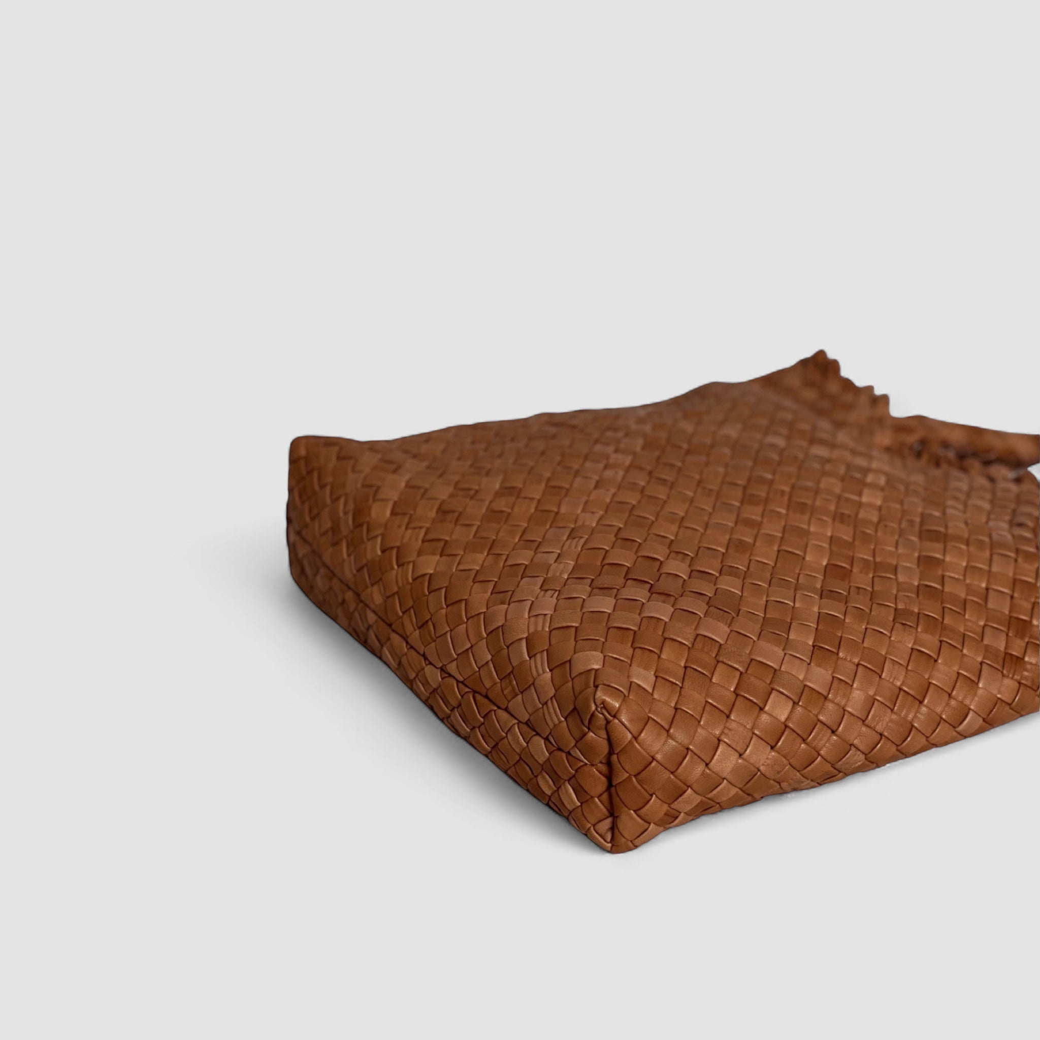 Ribichini Woodstock Babe skinnveske i cognacfarge: Flettede detaljer og fin konstruksjon synlig underfra, viser kvalitet og håndverk.