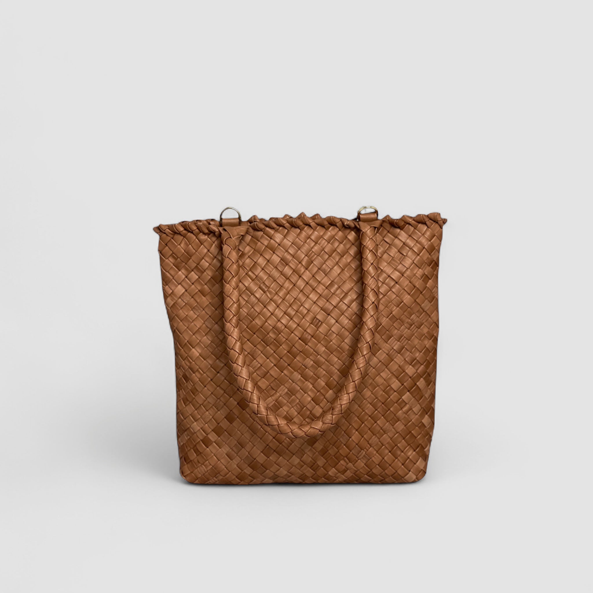 Ribichini Woodstock Babe i cognac er en tidløs skinnveske som skiller seg ut med sitt elegante design og flettemønster.