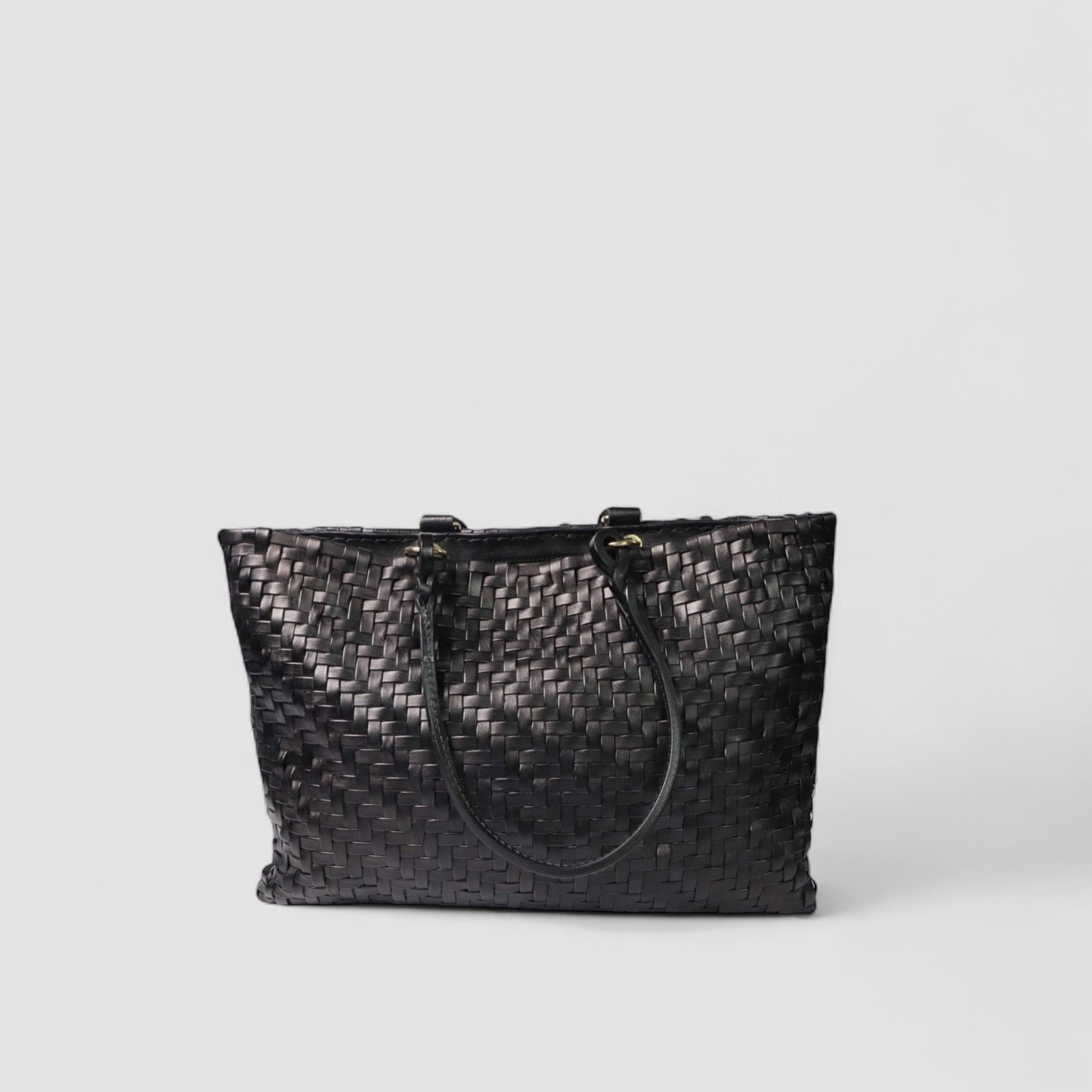 Ribichini Safari i sort lammeskinn er flettet i et vakkert fiskebensmønster, med dekorerte sorte hanker som legger til eleganse.