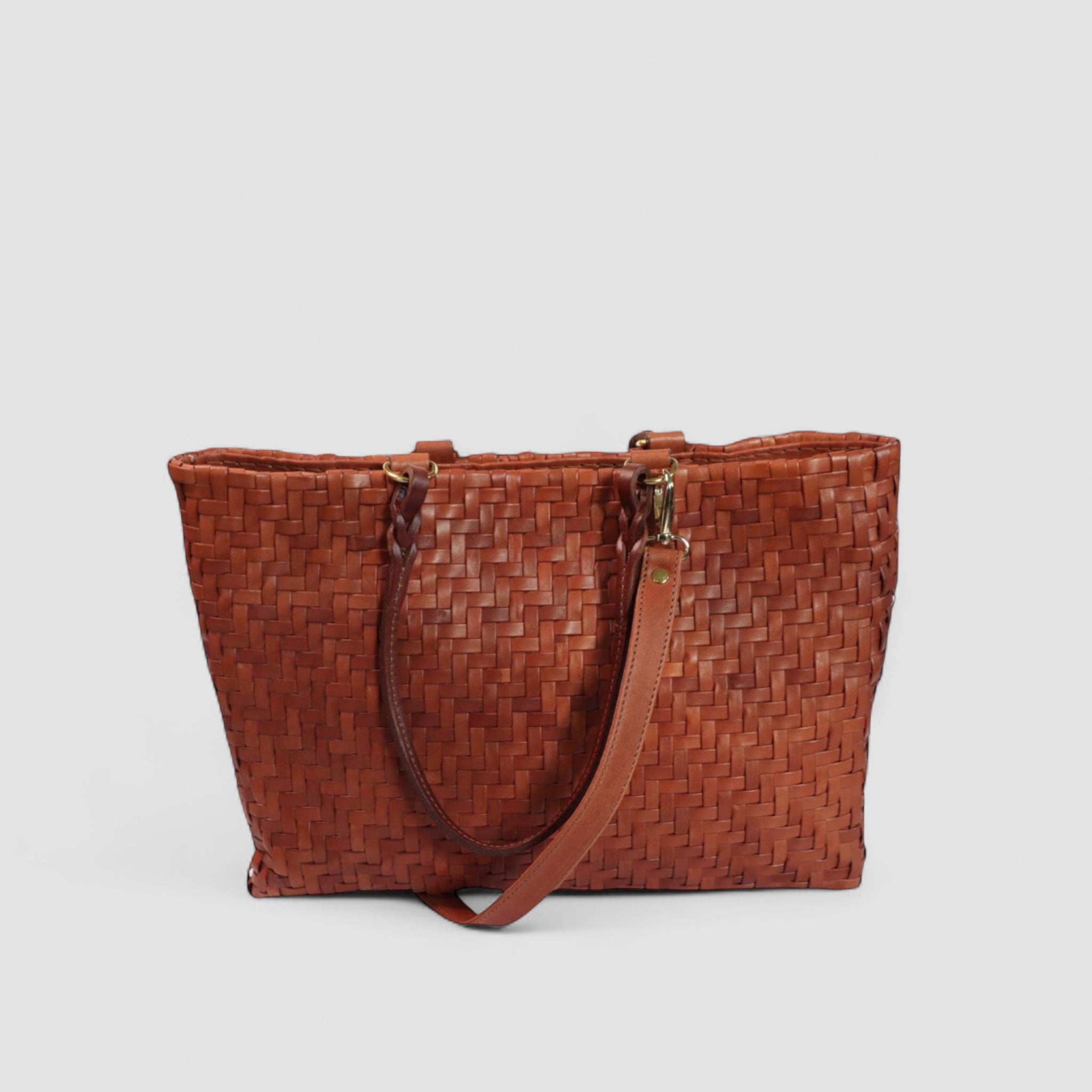Ribichini Safari-vesken i cognacfarget lammeskinn med det unike flettefiskebensmønsteret. De elegante hankedetaljene og den avtagbare skulderstroppen.