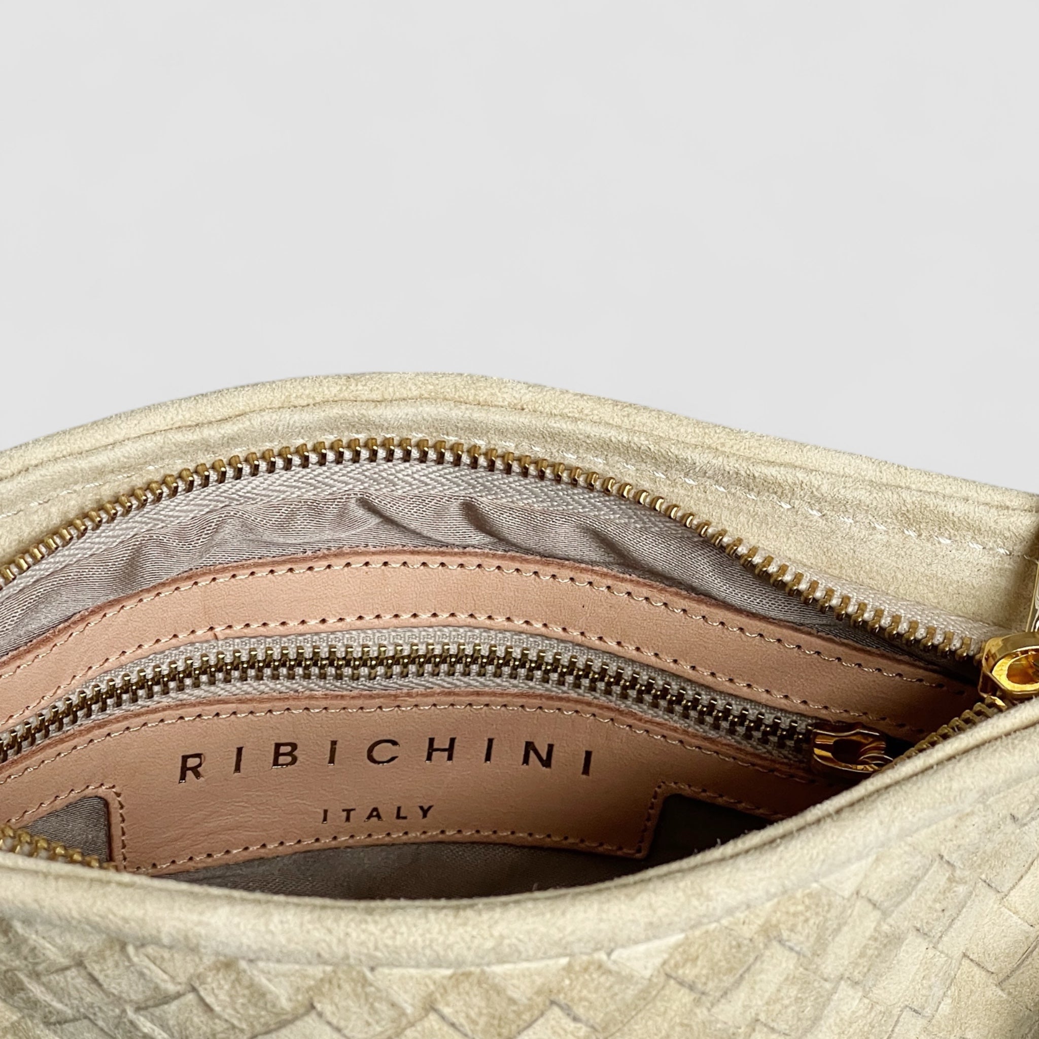 Dette bildet gir et innblikk i innsiden av Ribichini Camper clutch i kremfarge.