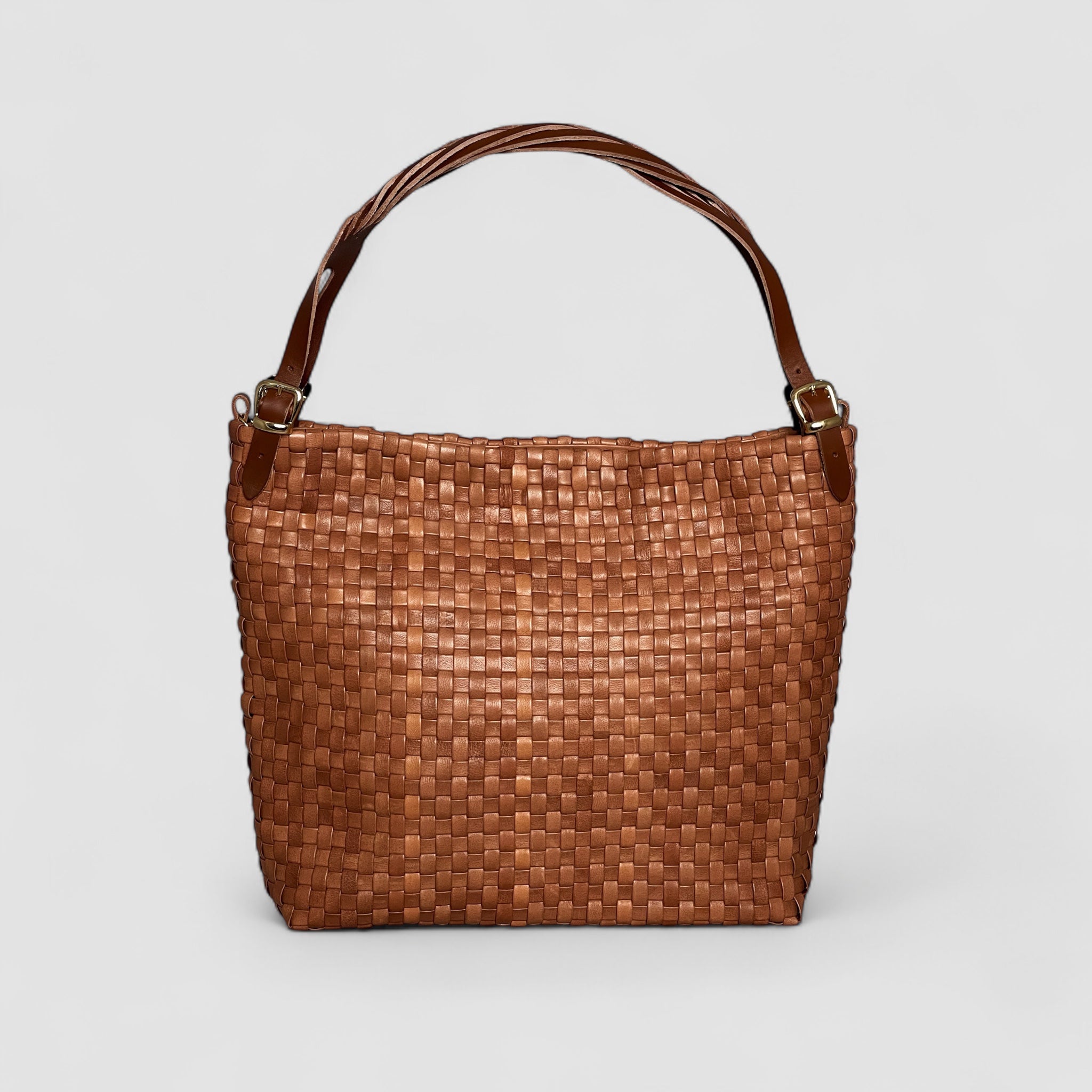 Ribichini Camper Clean skinnveske i cognac: glatt flettet lammeskinn, matchende hank og elegante gulldetaljer.