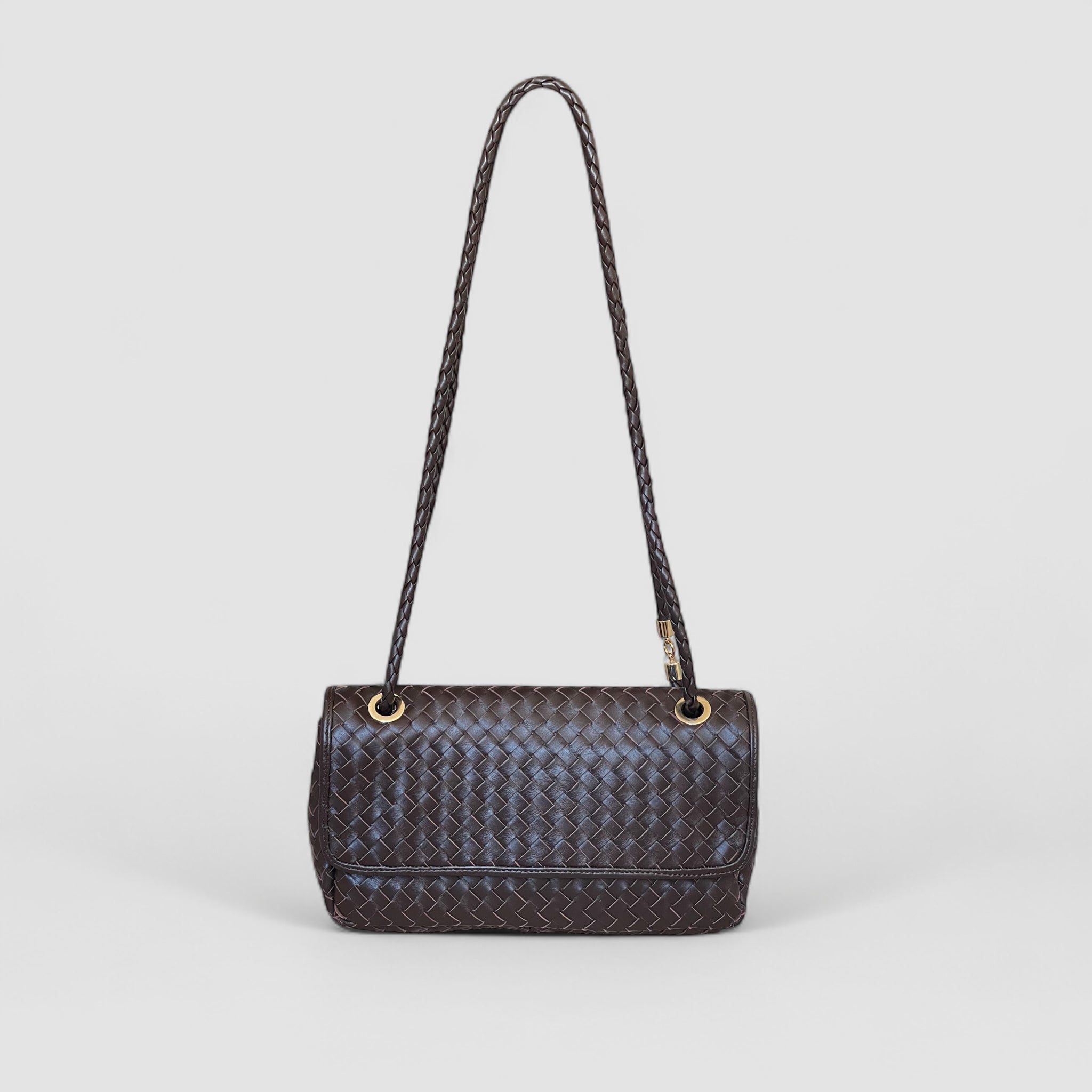 Ribichini Envelope-clutchen i sjokoladefarget lammeskinn med gull-detaljer. Justerbar skinnhank og praktisk klaff for lukking.