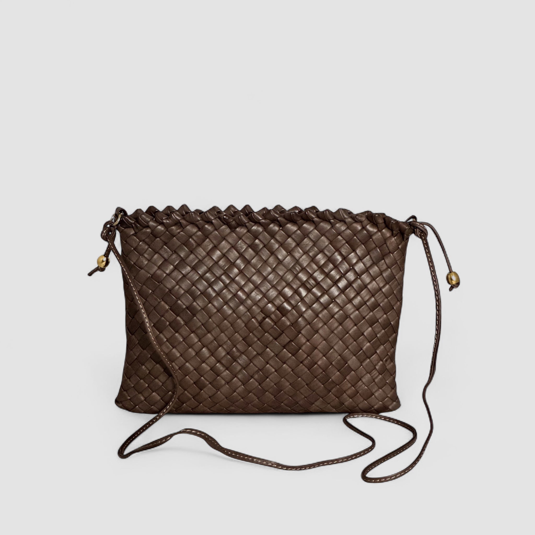 Ribichini Woodstock-clutchen i brunt skinn kombinerer elegant flettedesign med praktisk funksjonalitet.