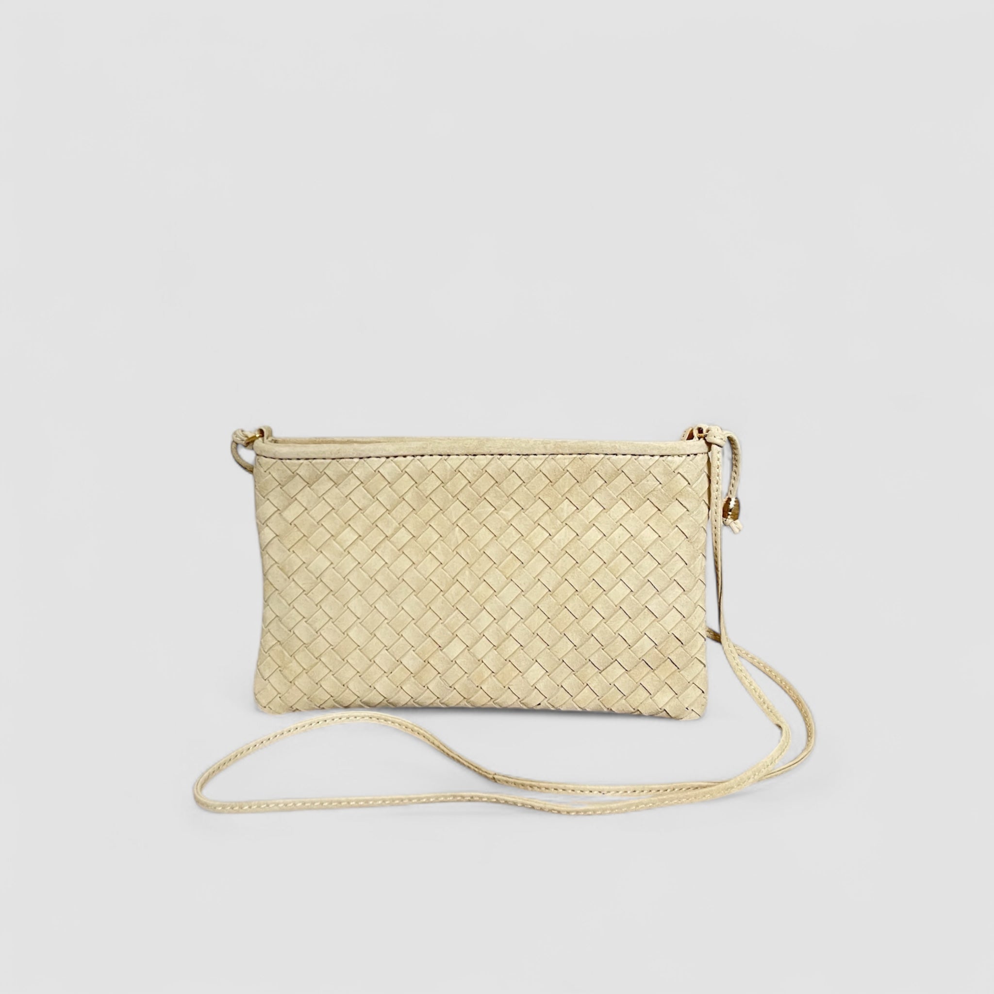 Ribichini Camper clutch i kremfarge. Den er laget av semsket lammeskinn, har et flettet design og gulldetaljer.