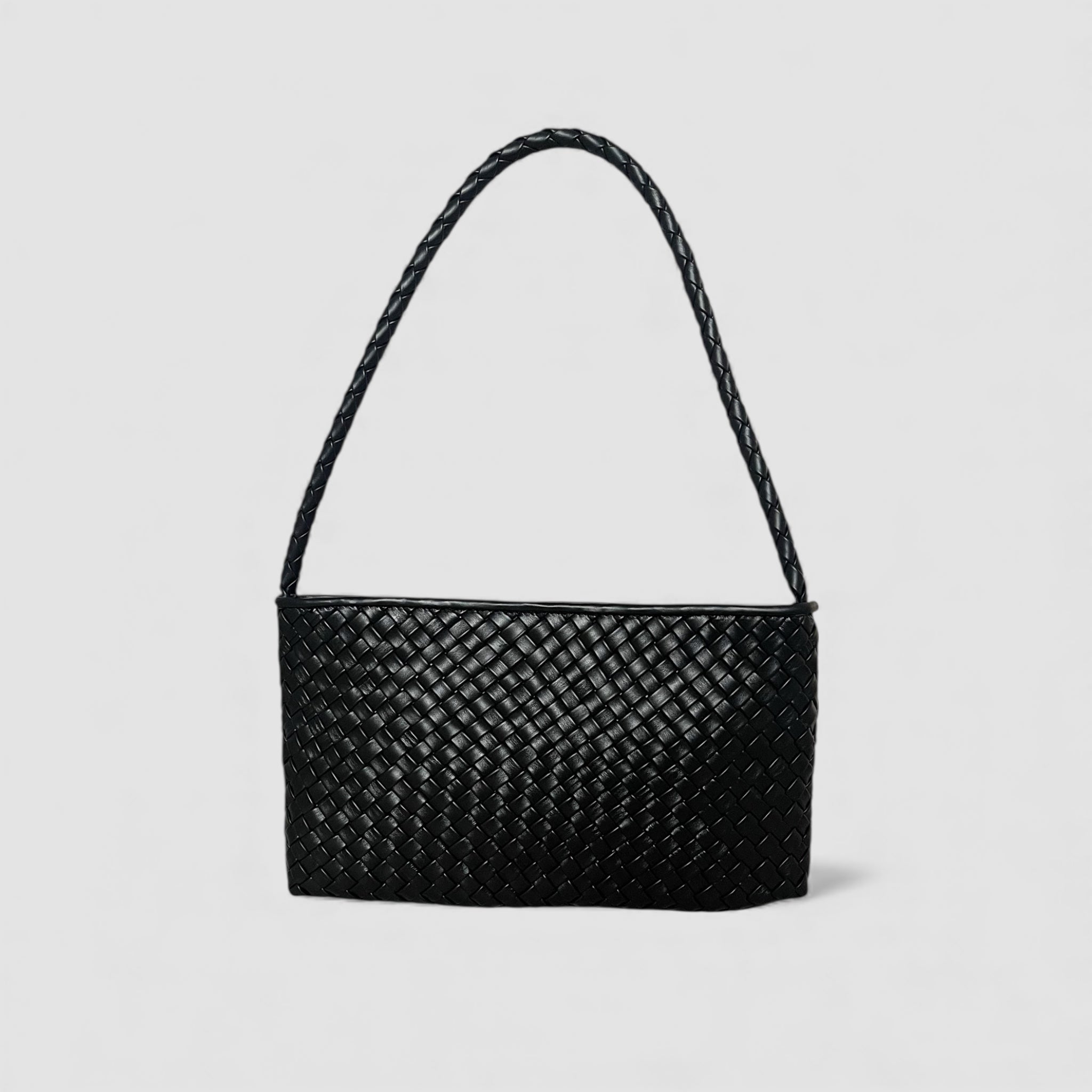 Sort Ribichini Classica skulderveske i håndflettet skinn med avlang form og flettet stropp på lys bakgrunn.