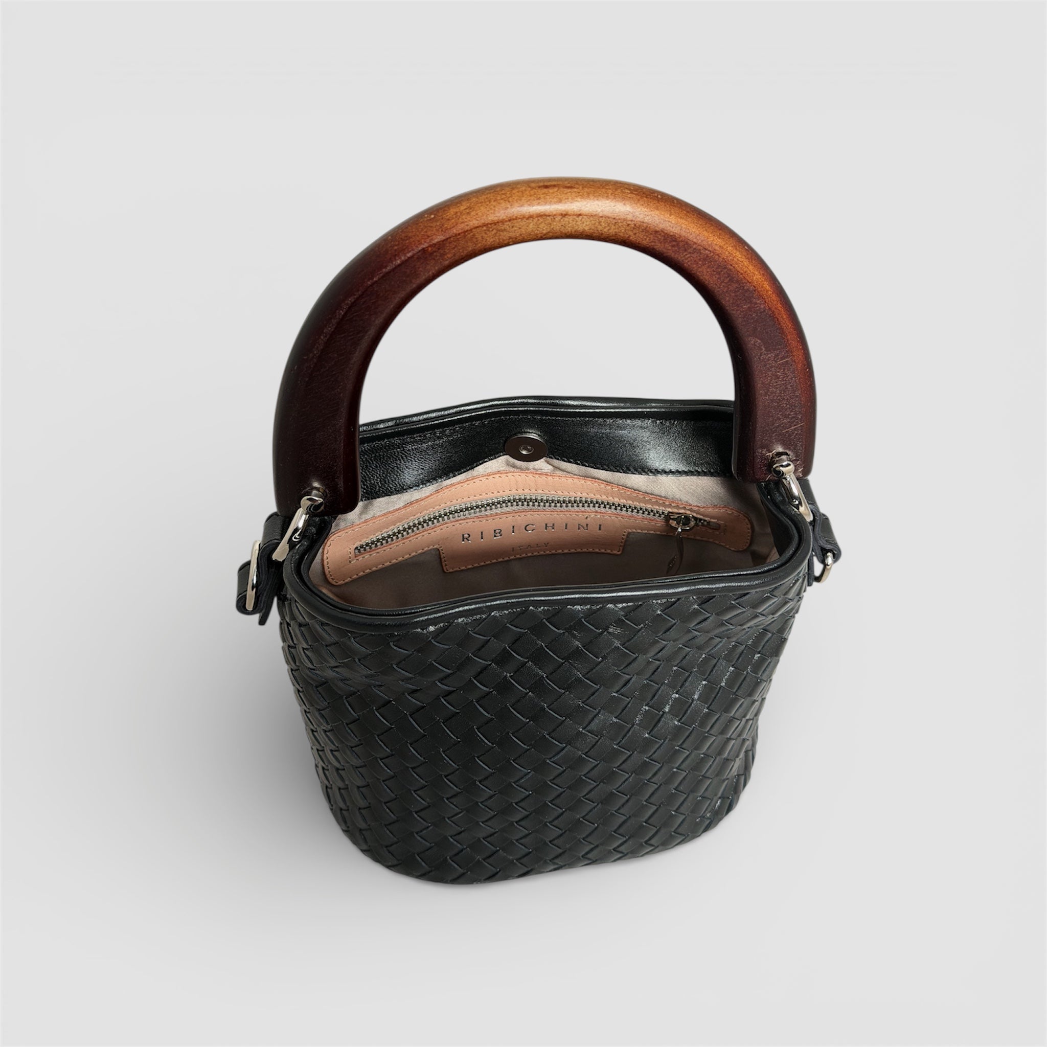 Innside av Ribichini Albero veske med skinnfôr, magnetlukking og innvendig glidelåslomme, håndlaget i Italia.