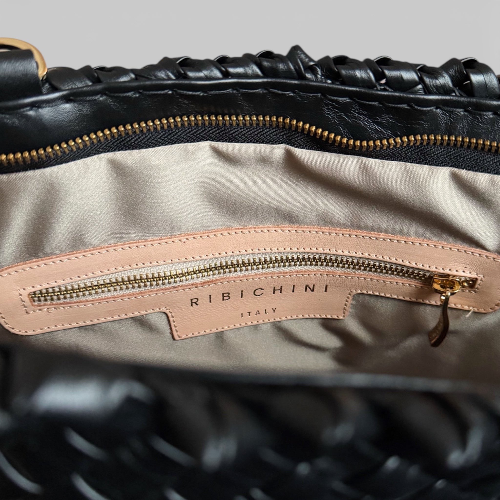 Innsiden av Ribichini Woodstock Classic er organisert og elegant, med praktiske lommer og rom. Gullfargede detaljer og ikonisk R-logo legger til luksus og stil.