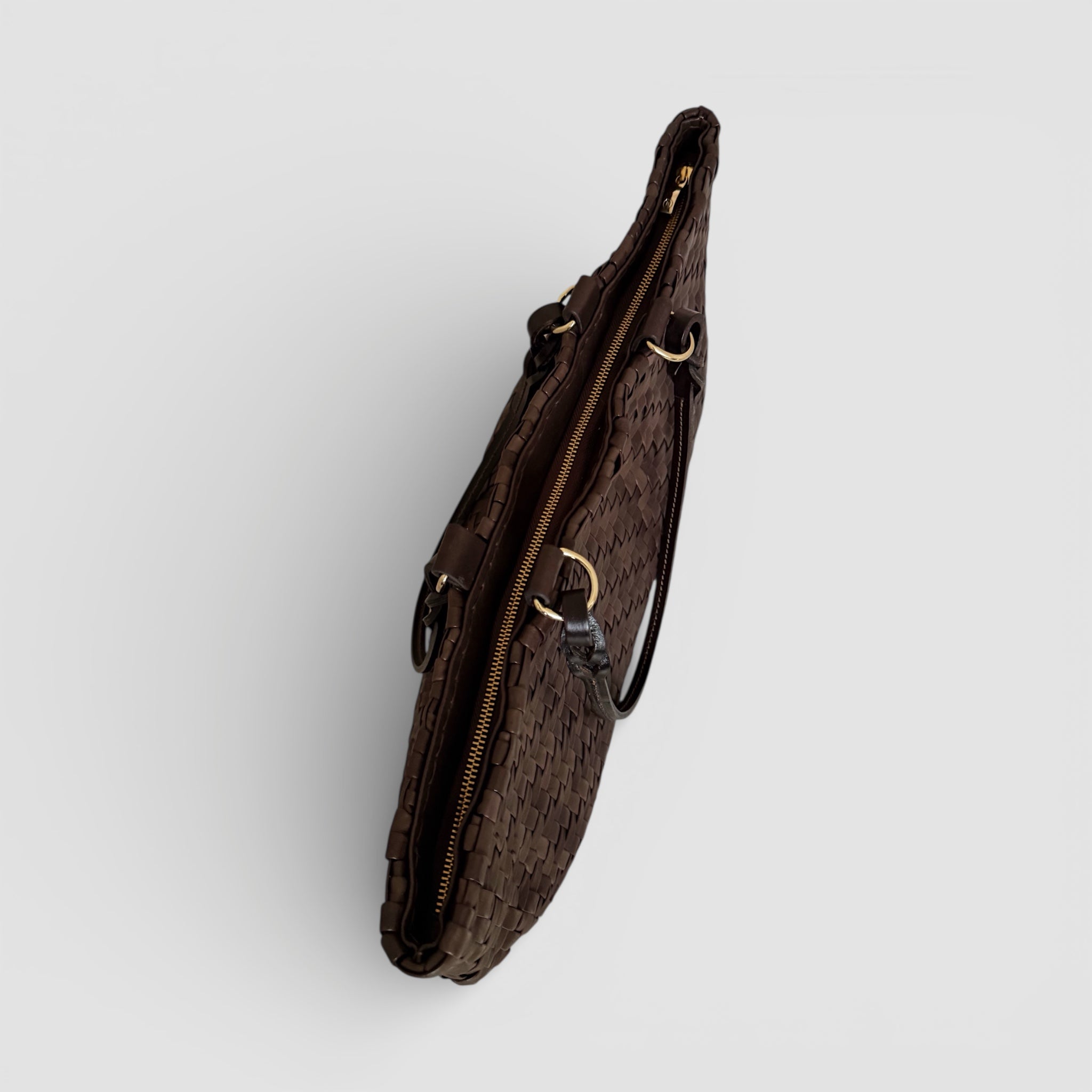 Safari i brunt – håndflettet skinnveske med glidelåslukking, strukturerte sider og elegante gulldetaljer.
