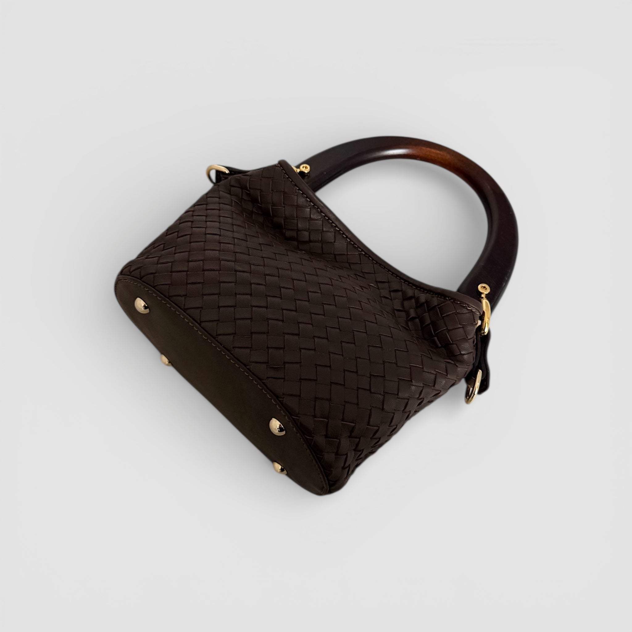 Bunn av Ribichini Albero veske i håndflettet brunt skinn med beskyttende metallføtter og trehåndtak.